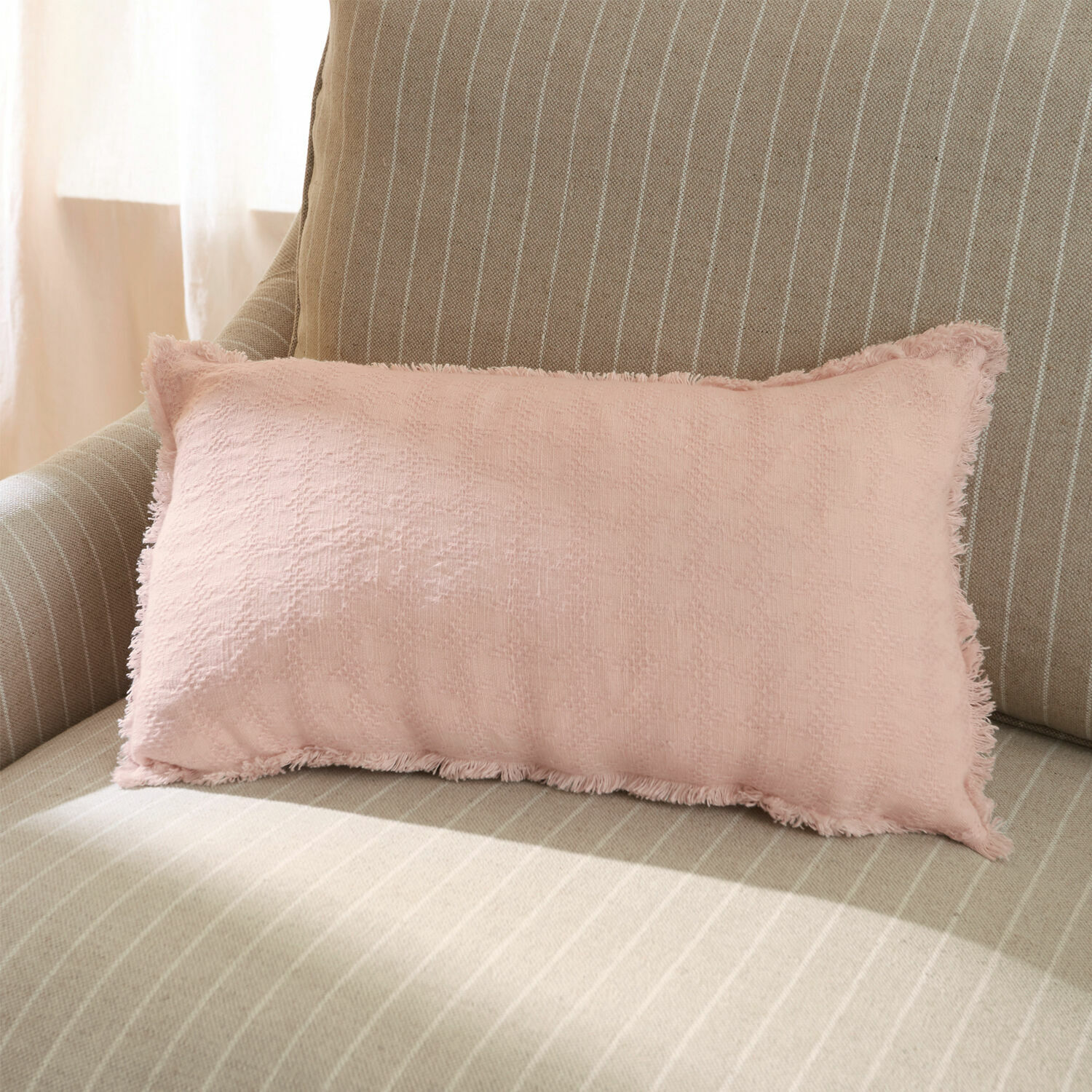Kussenhoes Saavreda Roze sierkussen van zachte stof op beige gestreepte bank voor een gezellige woonkamer
