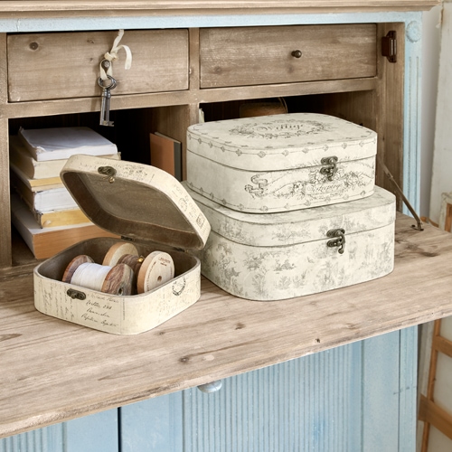 Set van drie crèmekleurige vintage decoratieve dozen op houten tafel, praktische opbergdozen