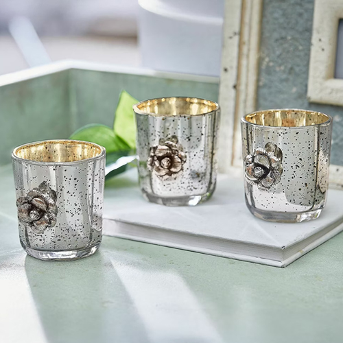 Set van drie glazen theelichthouders met metalen afwerking en bloemdecoratie, tafeldecoratie