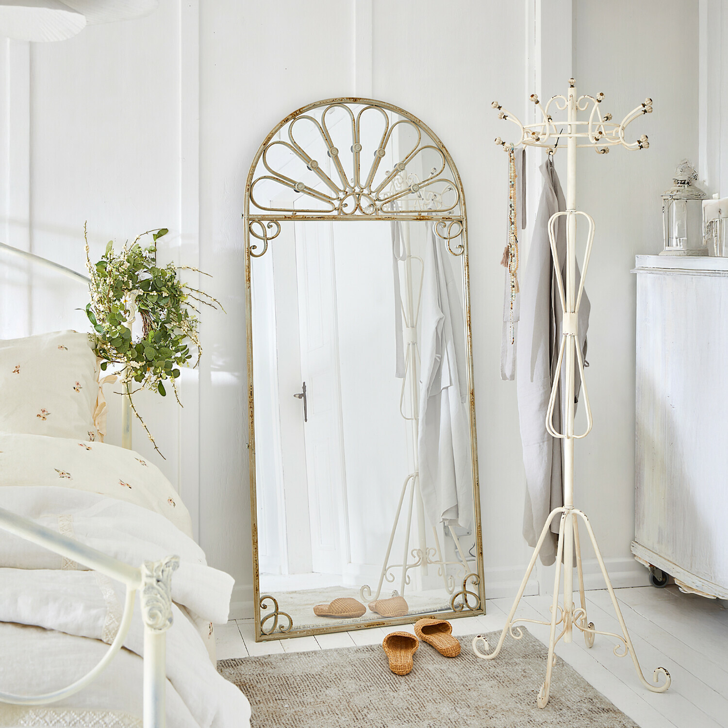 Grote staande spiegel met crèmekleurige metalen vintage lijst in lichte, gezellige slaapkamer
