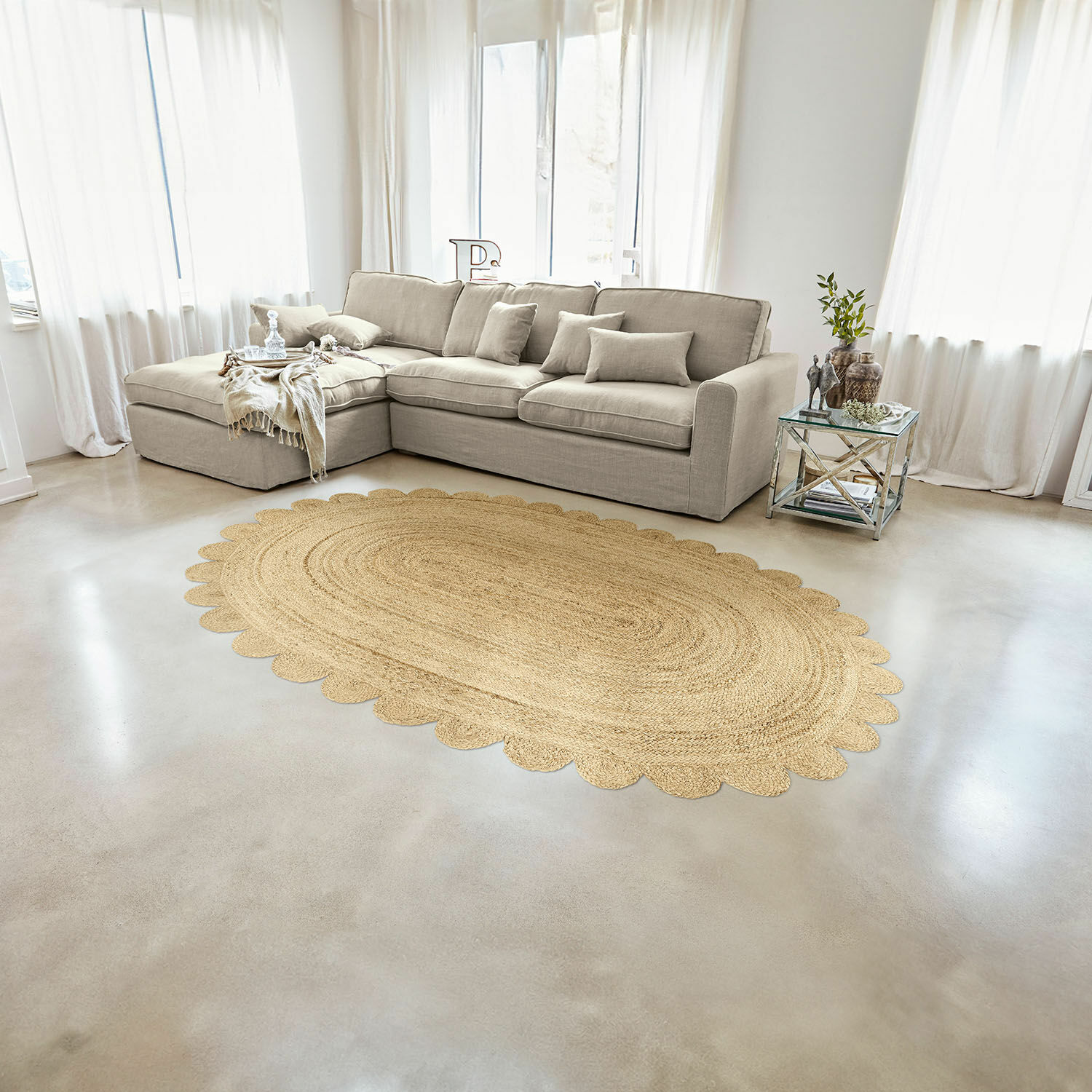 Ovale jute vloerkleed in natuurlijke kleur met gegolfde rand in lichte woonkamer met beige bank