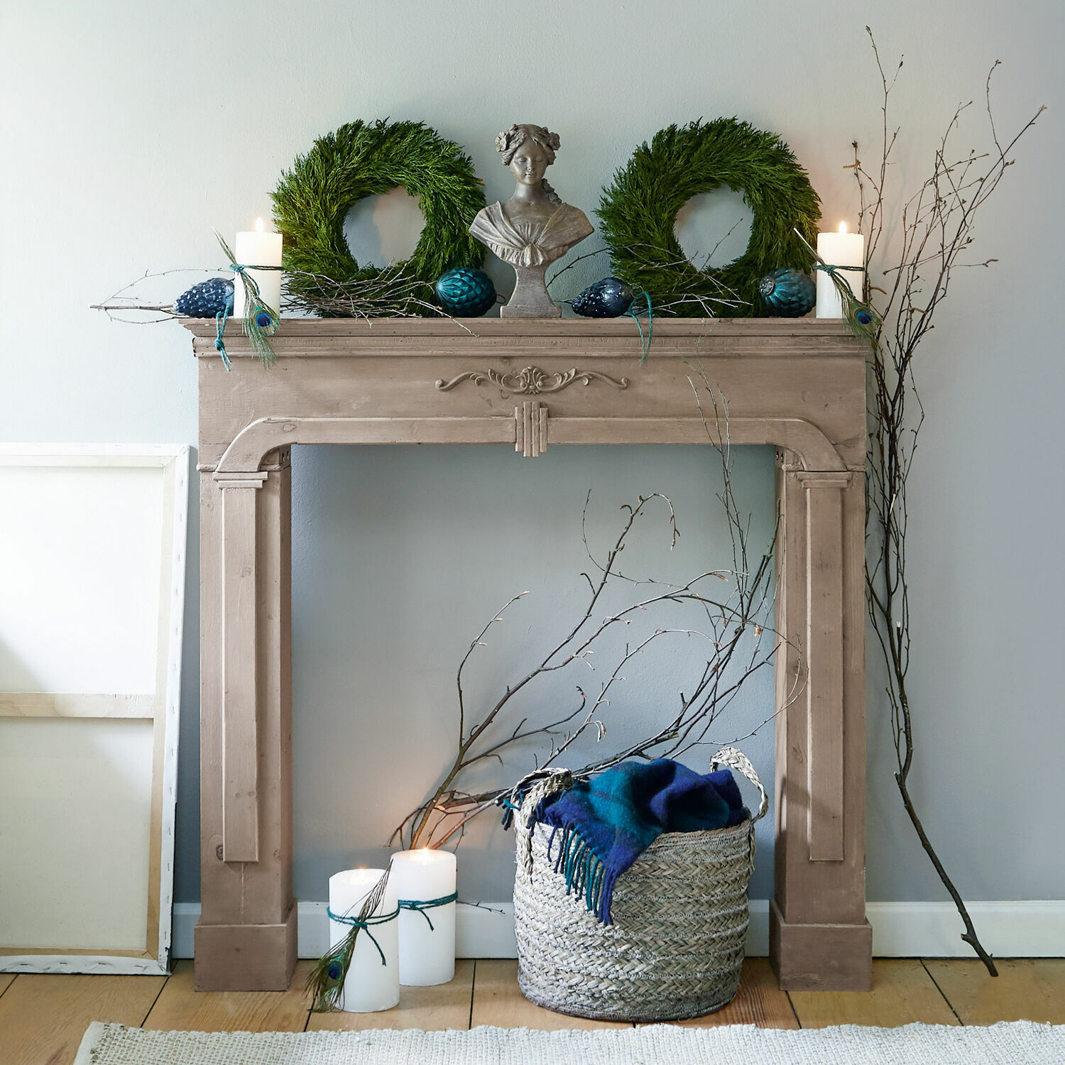 Decoratieve beige houten schoorsteen met groene kransen en kaarsen voor interieurdecoratie