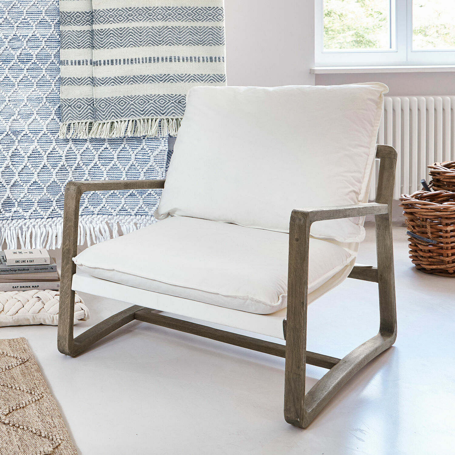 Fauteuil Jowna Stoel met houten frame en wit katoenen kussen in lichte, moderne kamer