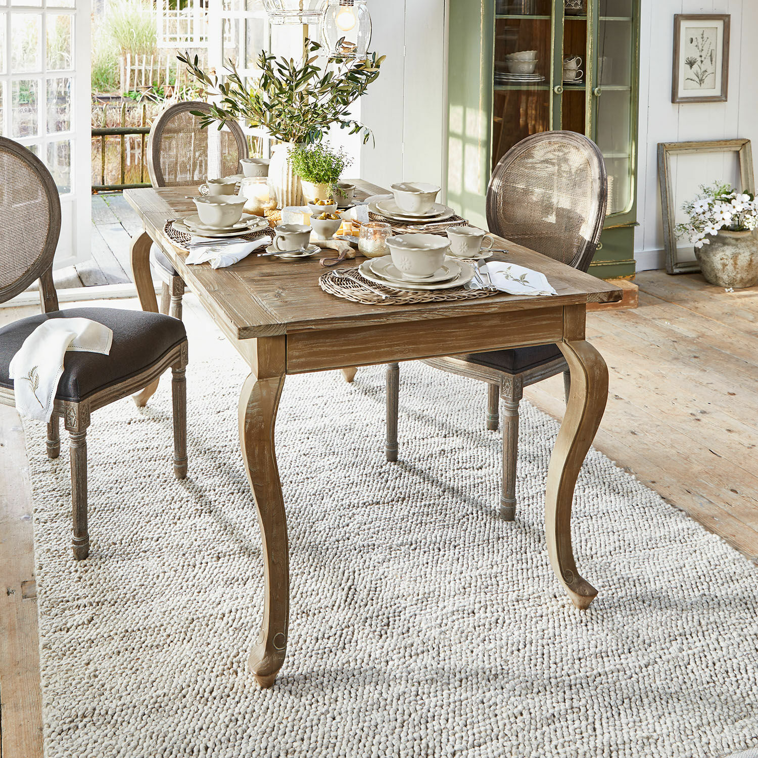 Tafel Plaish Rustieke houten eettafel met sierlijke poten en lichte serviesdecoratie in lichte kamer