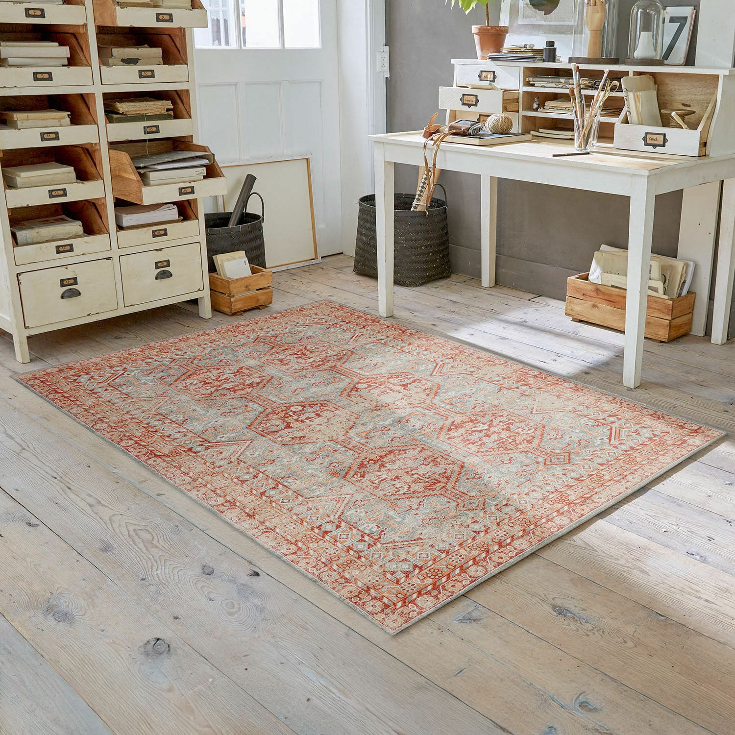 Vloerkleed Incantaro Vloerkleed met rood-beige patroon op lichte houten vloer in een lichte kamer met vintage inrichting