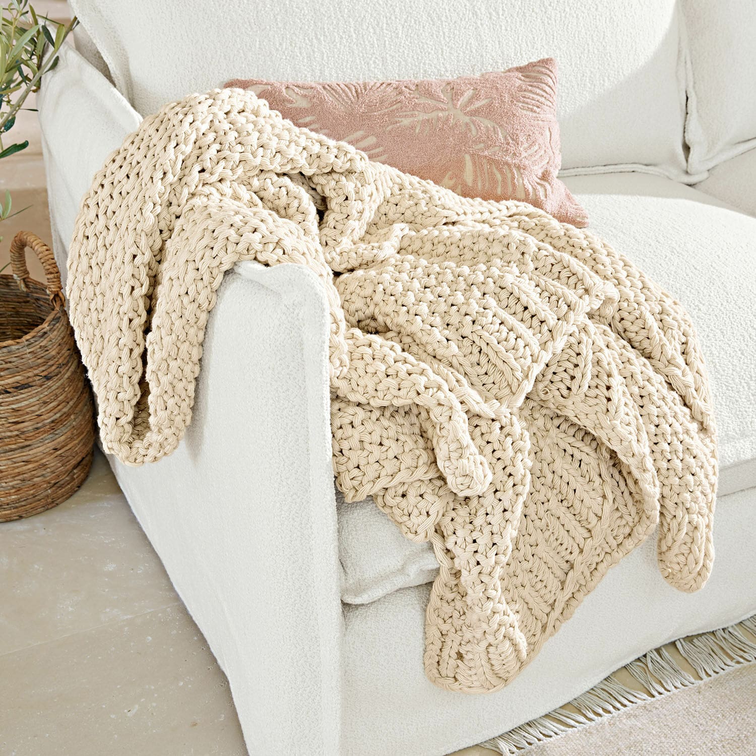 Plaid Plixoren Beige, grof handgebreid katoenen deken op witte bank in lichte kamer
