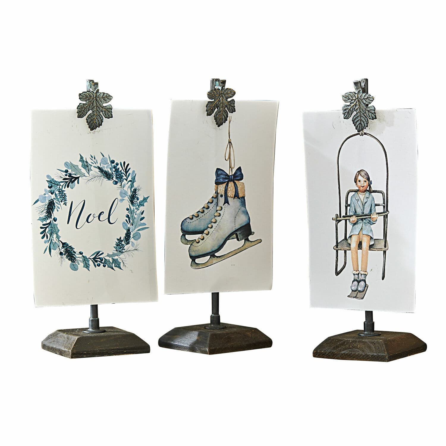 Afbeelding met houder set van 3 Herveline Drie kerstdecoraties op standaards met metalen clips, motieven van schaatsen, meisje en tekst Noel