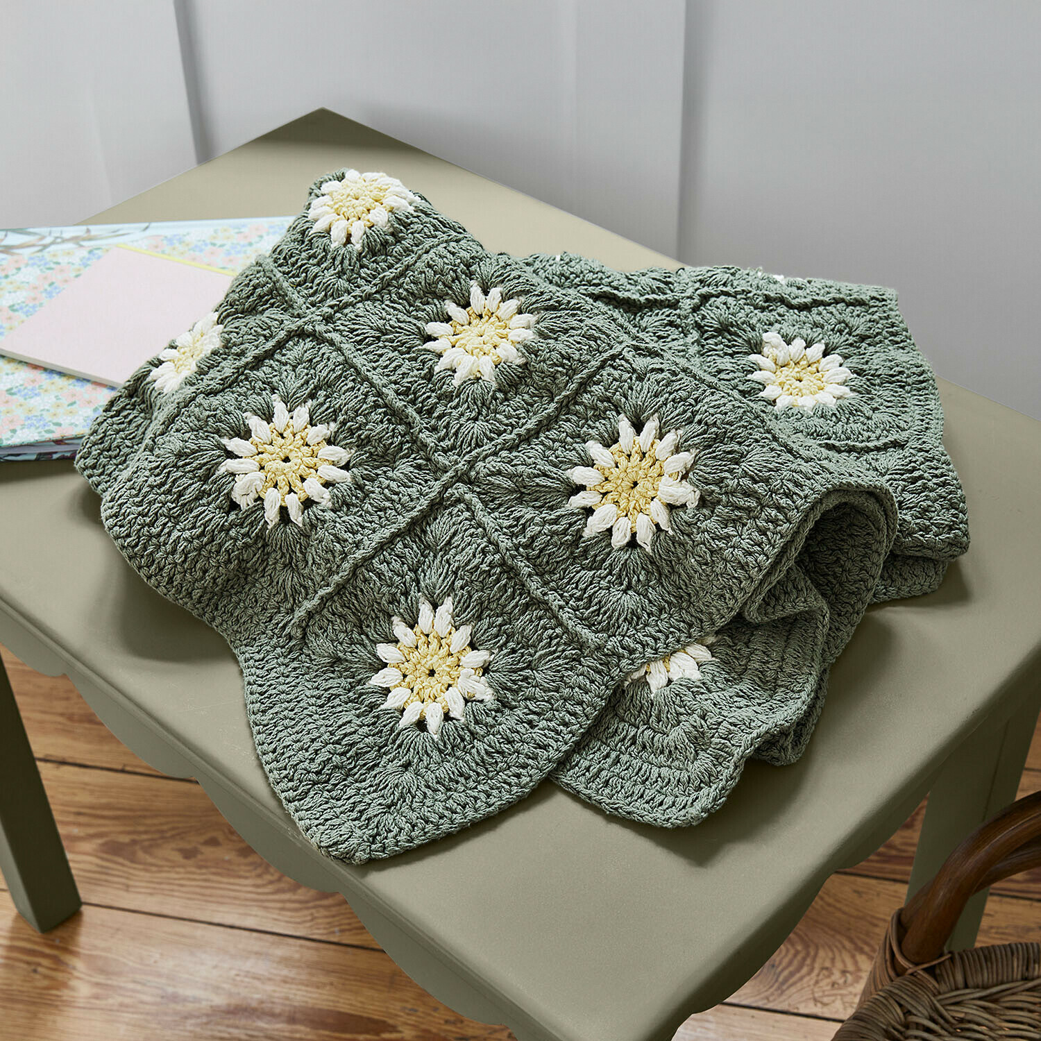 Met de hand gehaakte groene deken met witte bloemmotieven, zacht en decoratief voor thuis