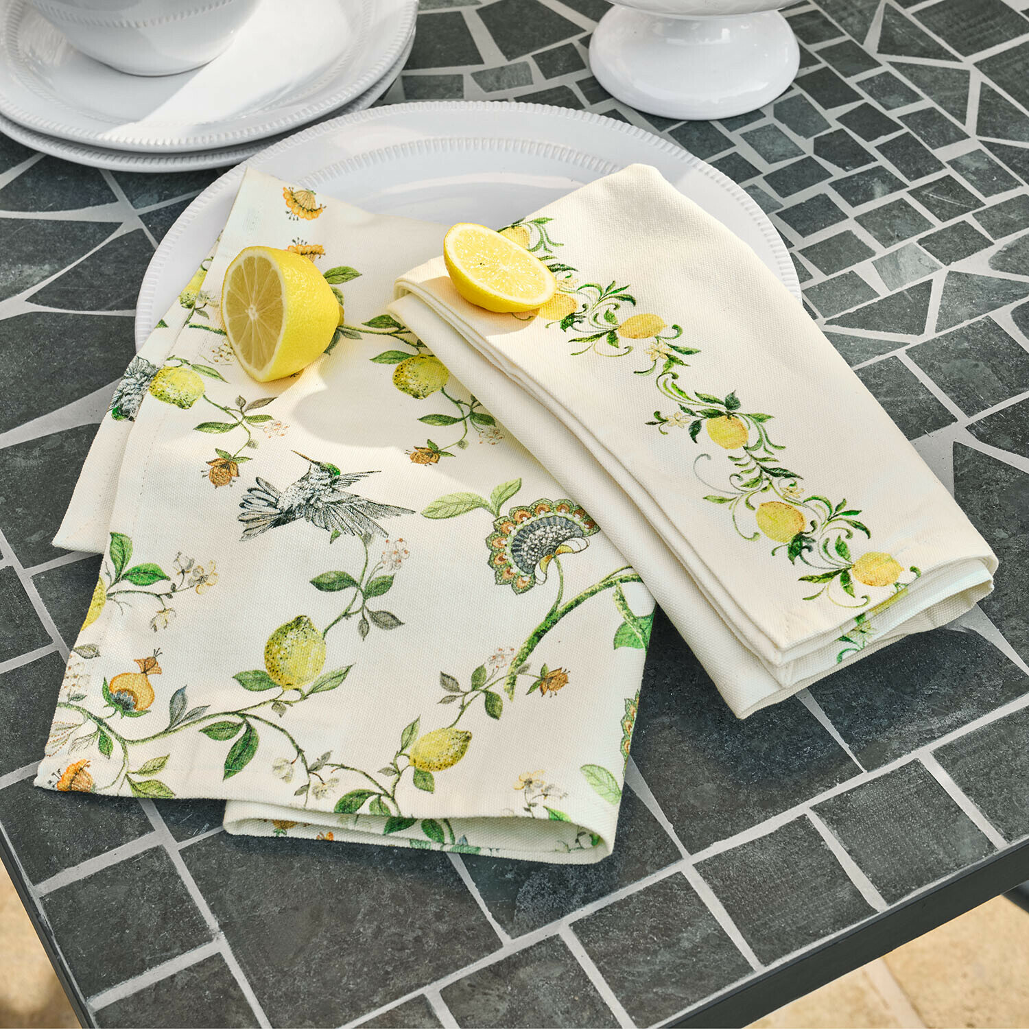 Linnen servetten met citroen- en vogelmotief op grijze stenen tafel voor tafeldecoratie