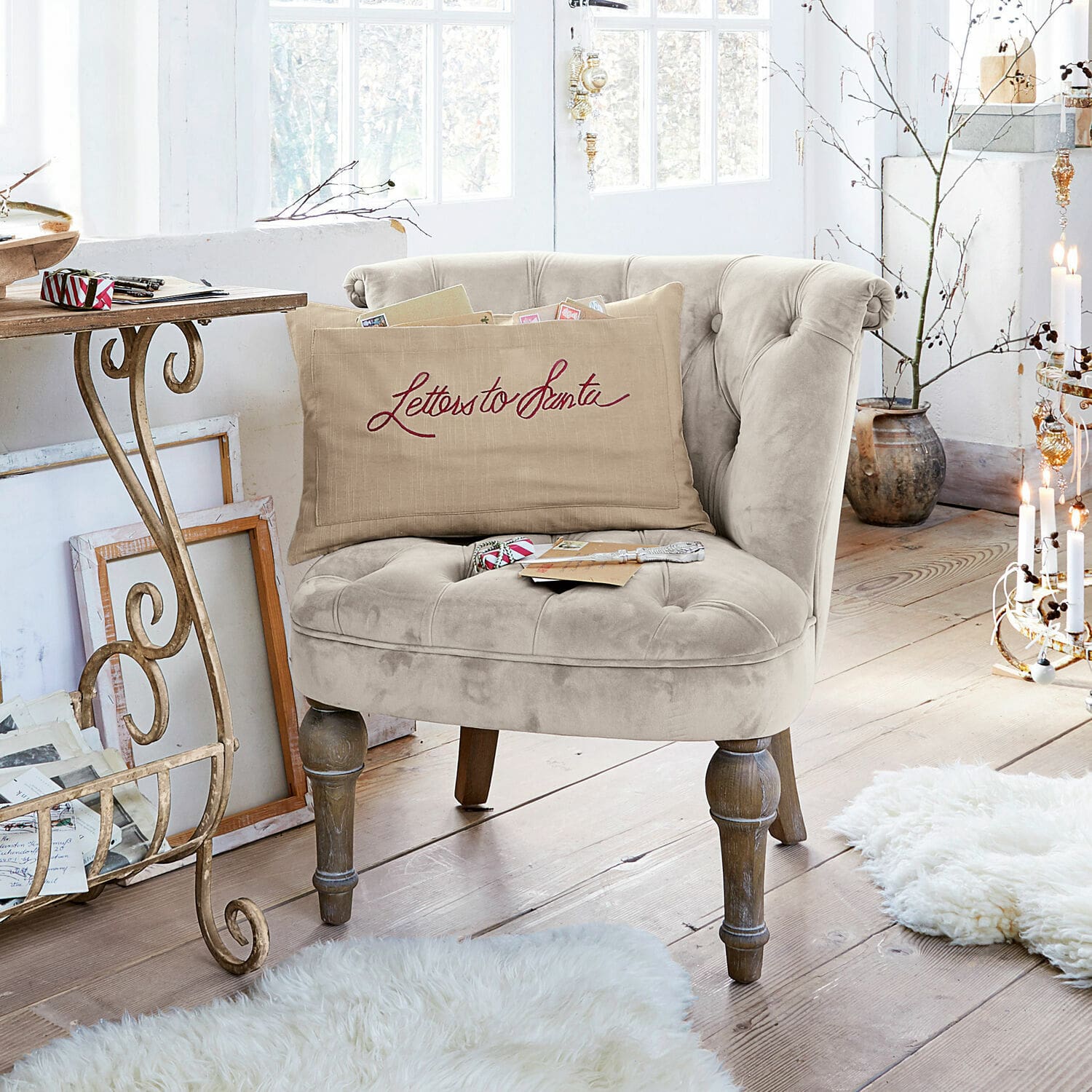 Beige fluwelen fauteuil met houten poten in lichte kamer met decoratief kussen