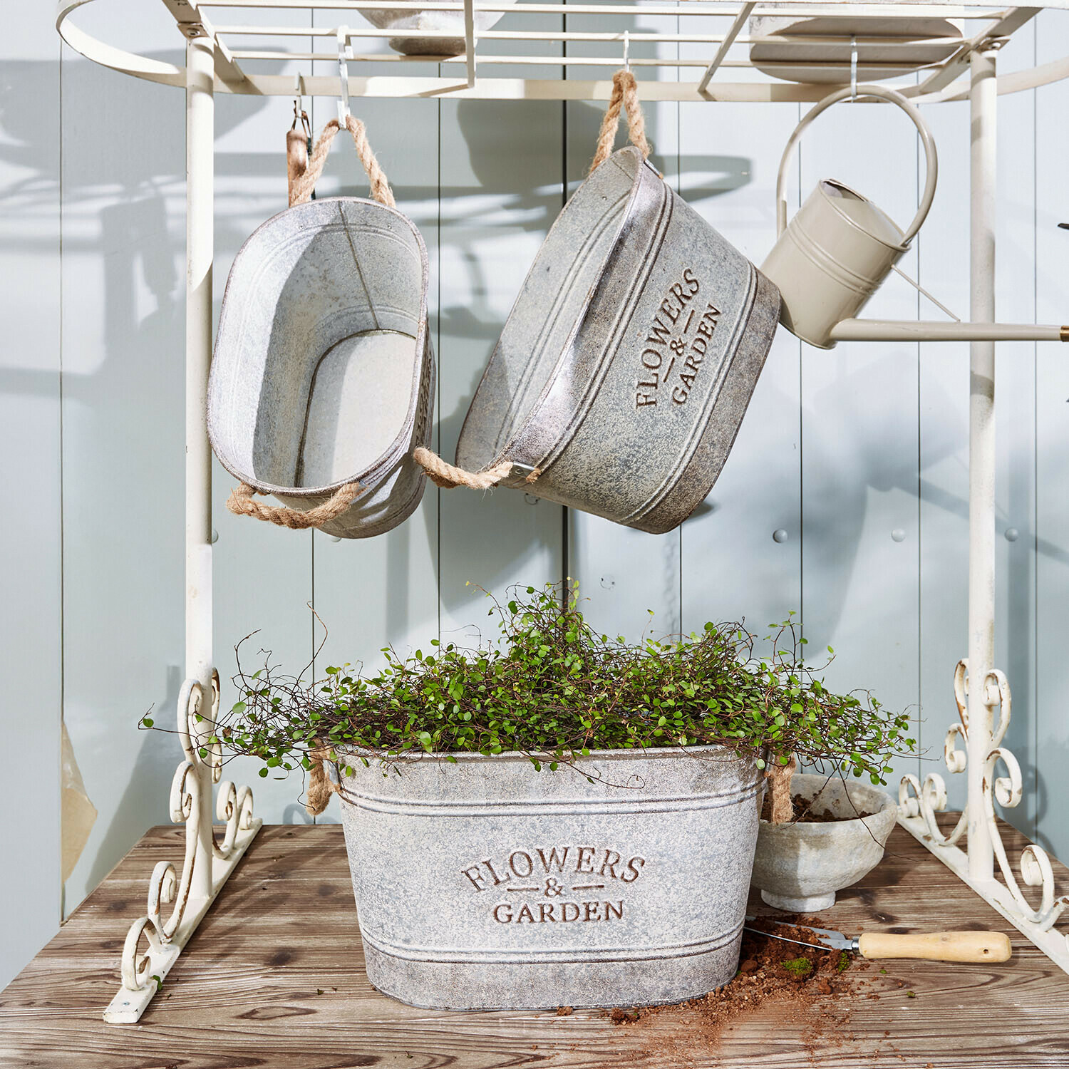 Sierpot set van 3 Merrin Grijze metalen plantenbakken met tekst Flowers & Garden, groene plant en tuingereedschap op houten tafel