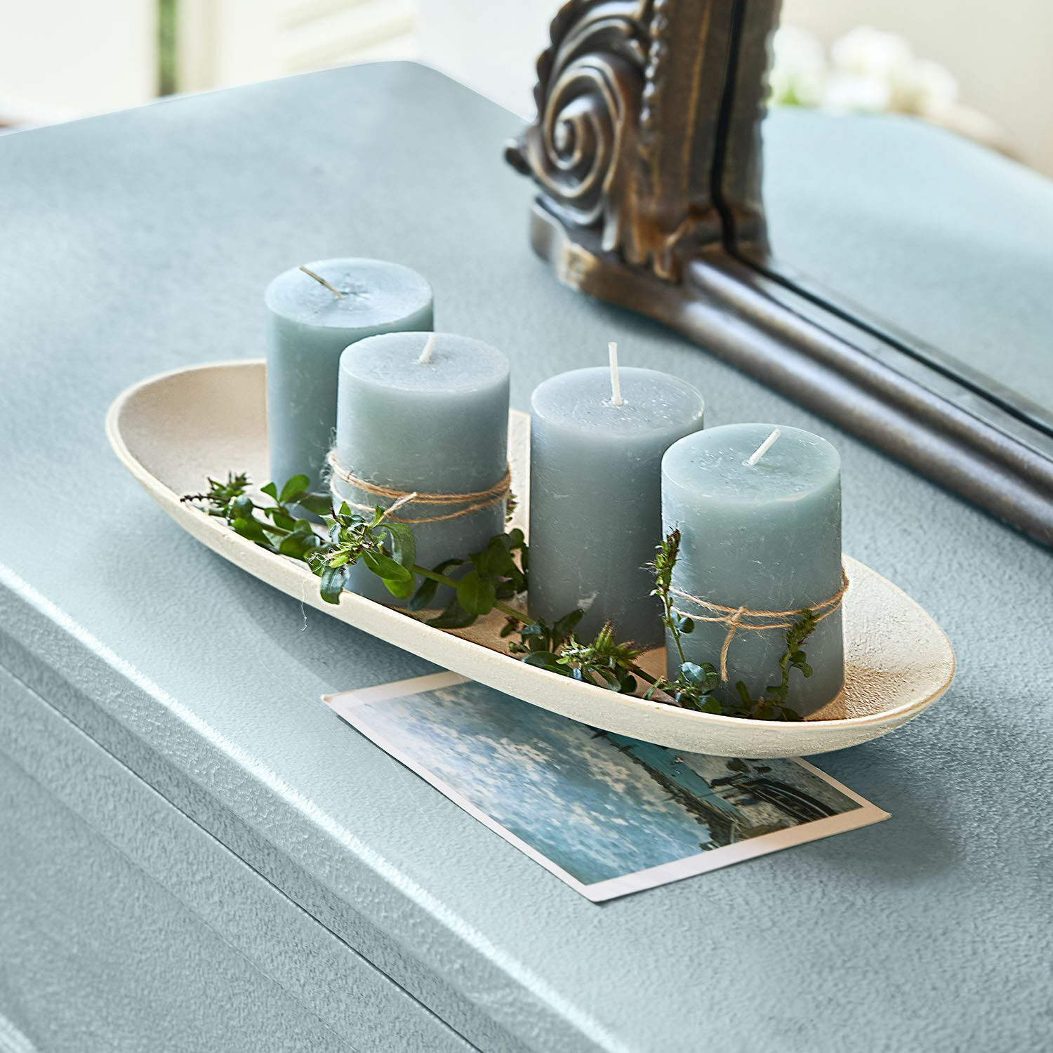 Schaal Cantresse Set van vier blauwe kaarsen met groene bladeren op een beige schaal op een tafel