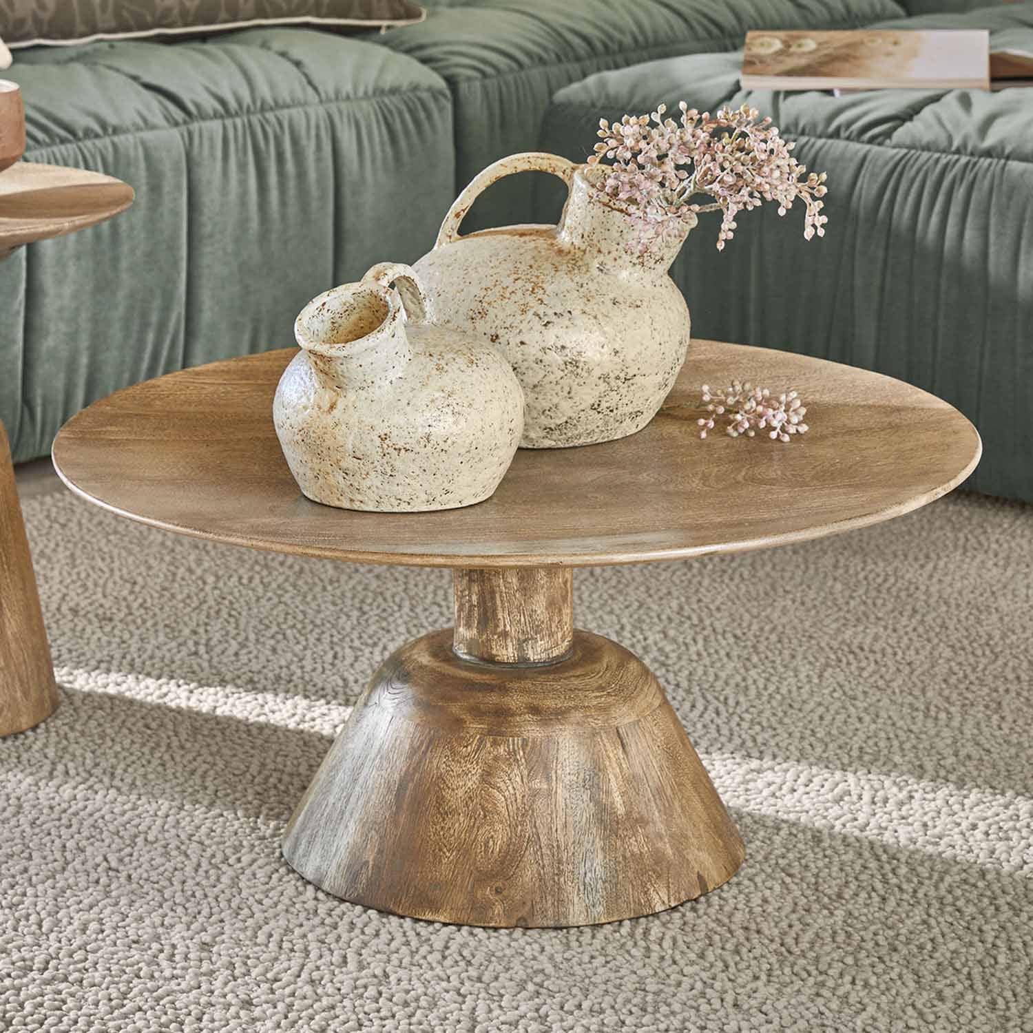 Houten salontafel met twee crèmekleurige keramische vazen in rustieke stijl op een beige tapijt