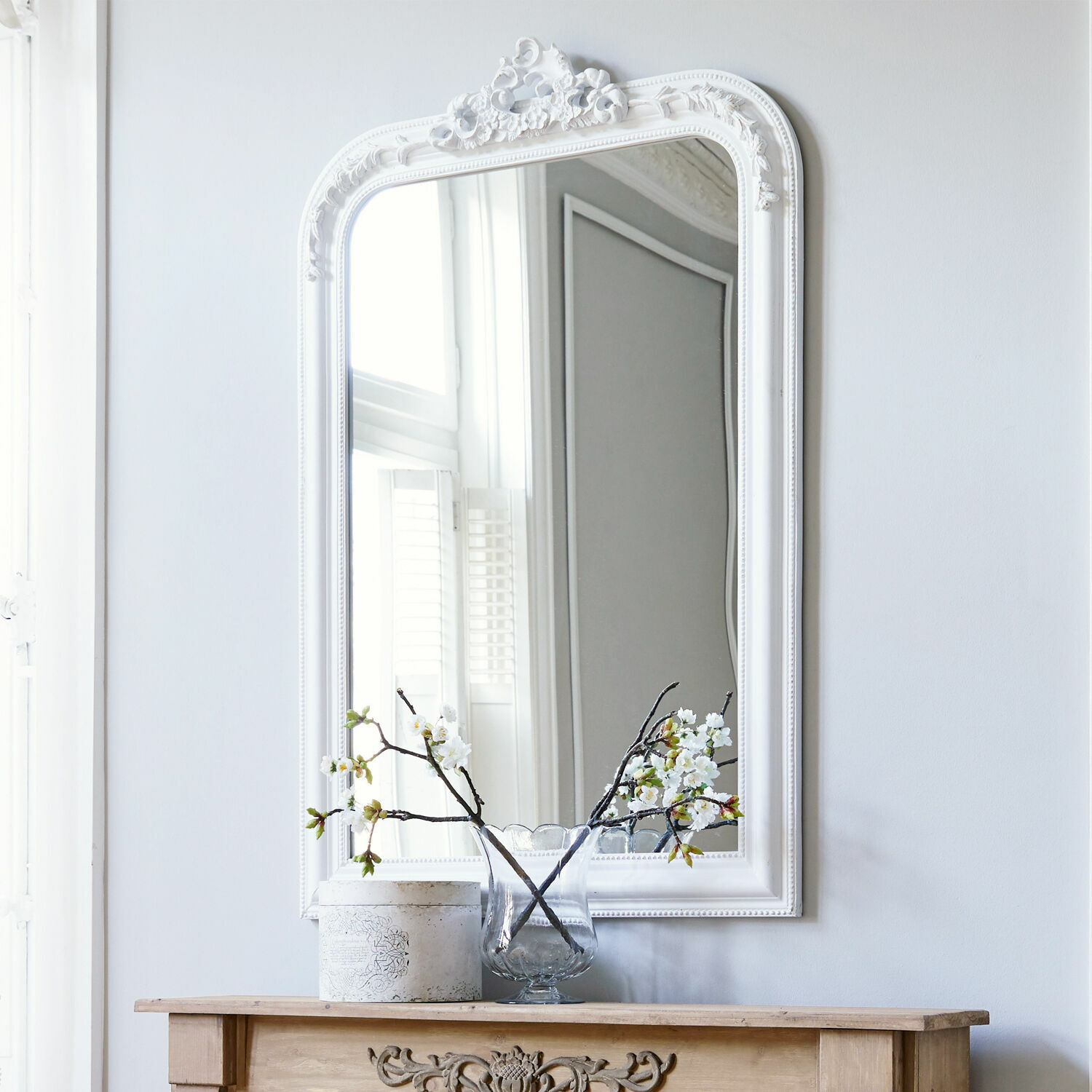 Spiegel Aubais Witte decoratieve spiegel met kunststof lijst boven houten schoorsteen met vaas en bloemen