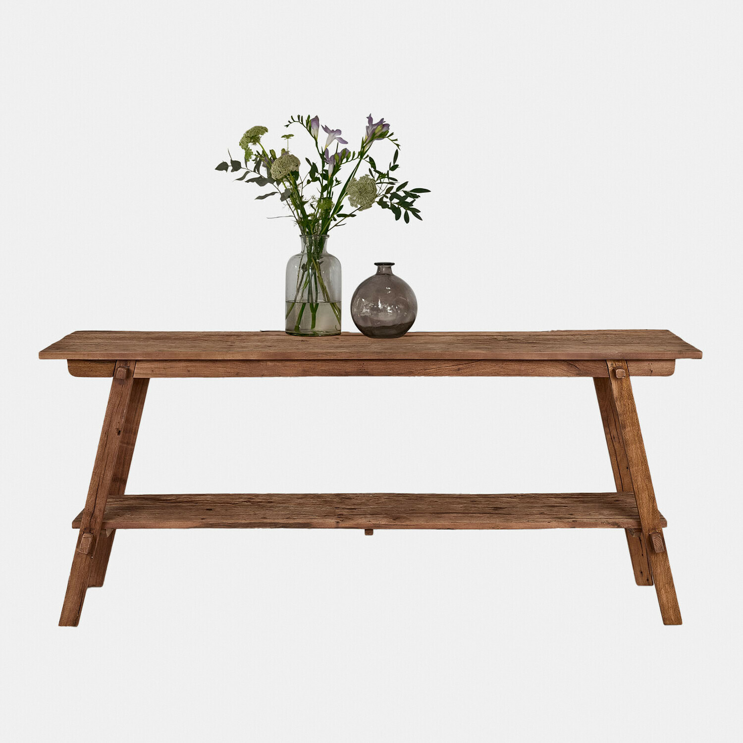 Rustieke houten tafel in natuurlijke houtkleur met plank en bloemendecoratie erop