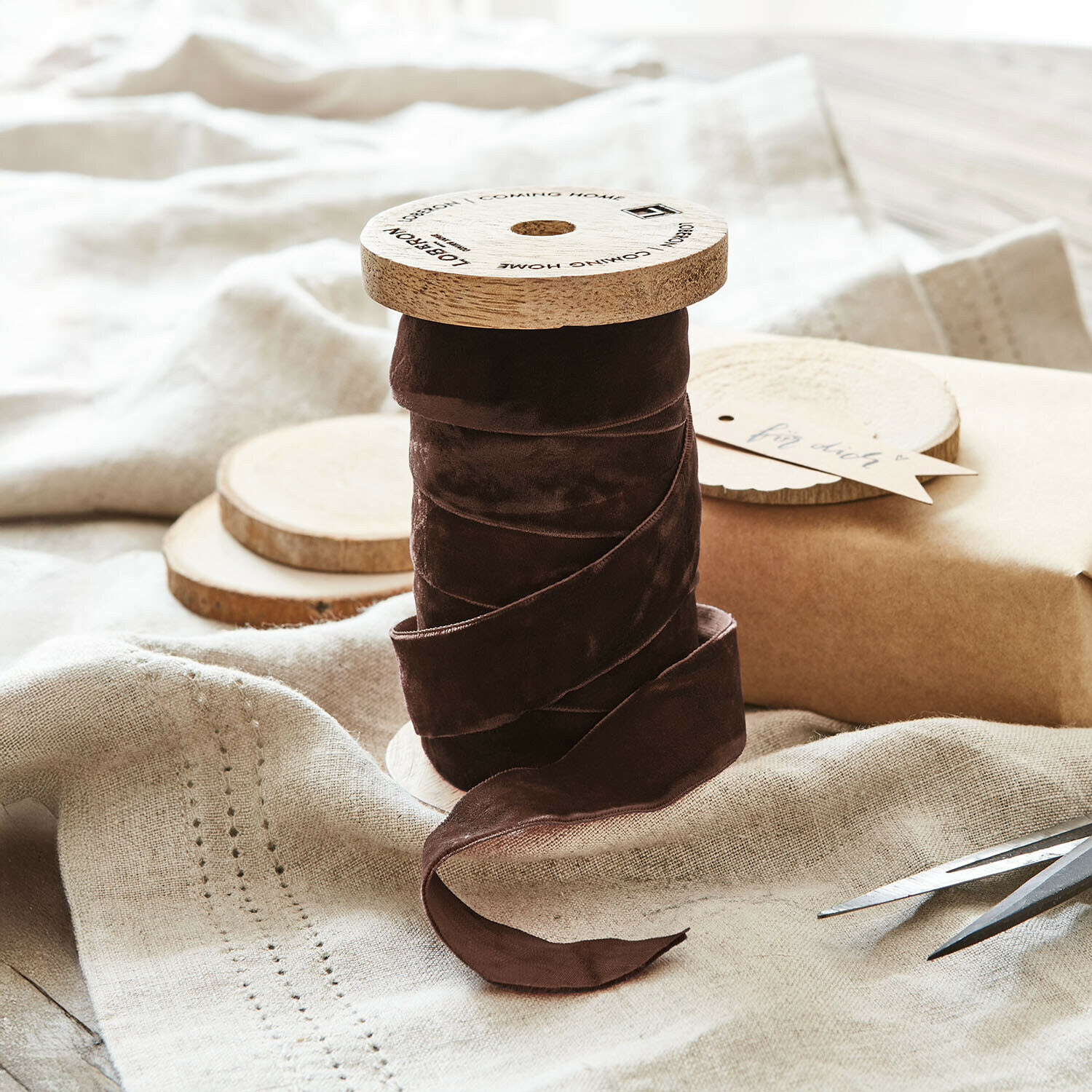 Bruine fluwelen lint op houten spoel op linnen stof voor decoratie en handwerk