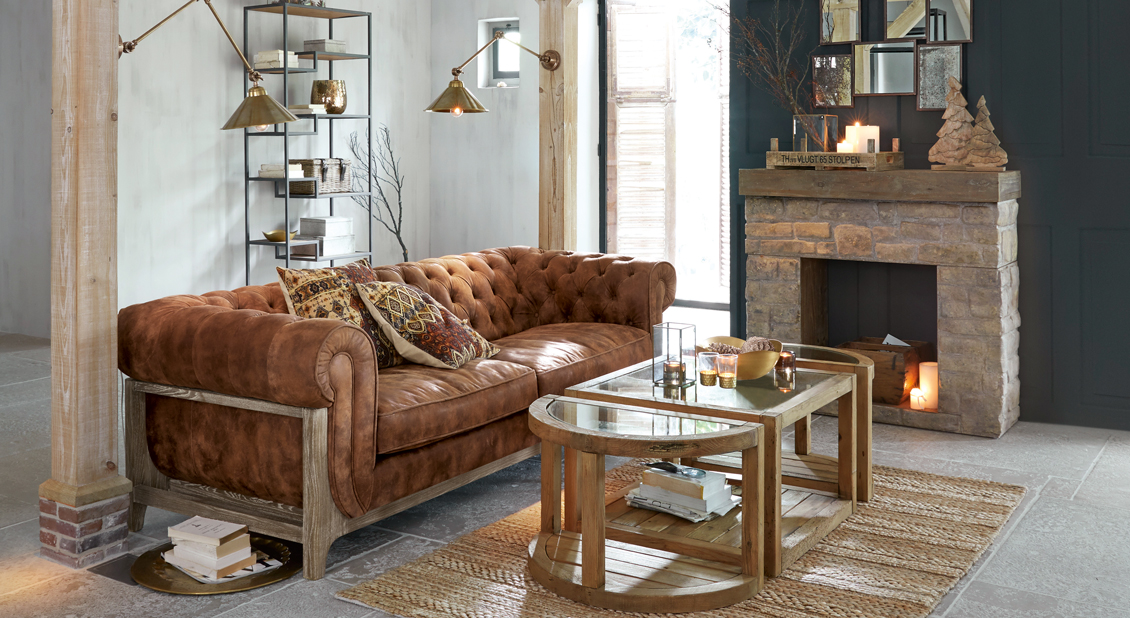 Bruine Chesterfield leren bank met houten frame in stijlvolle woonkamer met open haard en salontafel