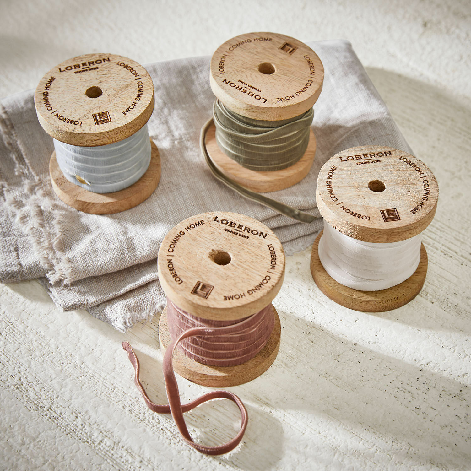 Fluwelen lint set van 4 Hilary Houten spoelen met fluwelen linten in pasteltinten op linnen stof, interieurdecoratie