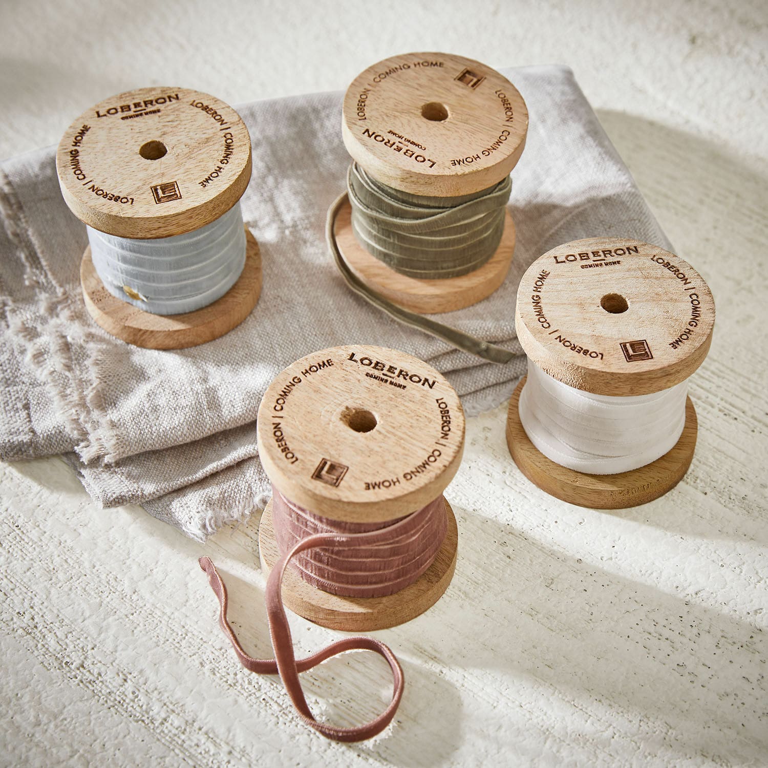 Fluwelen lint set van 4 Hilary Houten spoelen met fluwelen linten in pasteltinten op linnen stof, interieurdecoratie