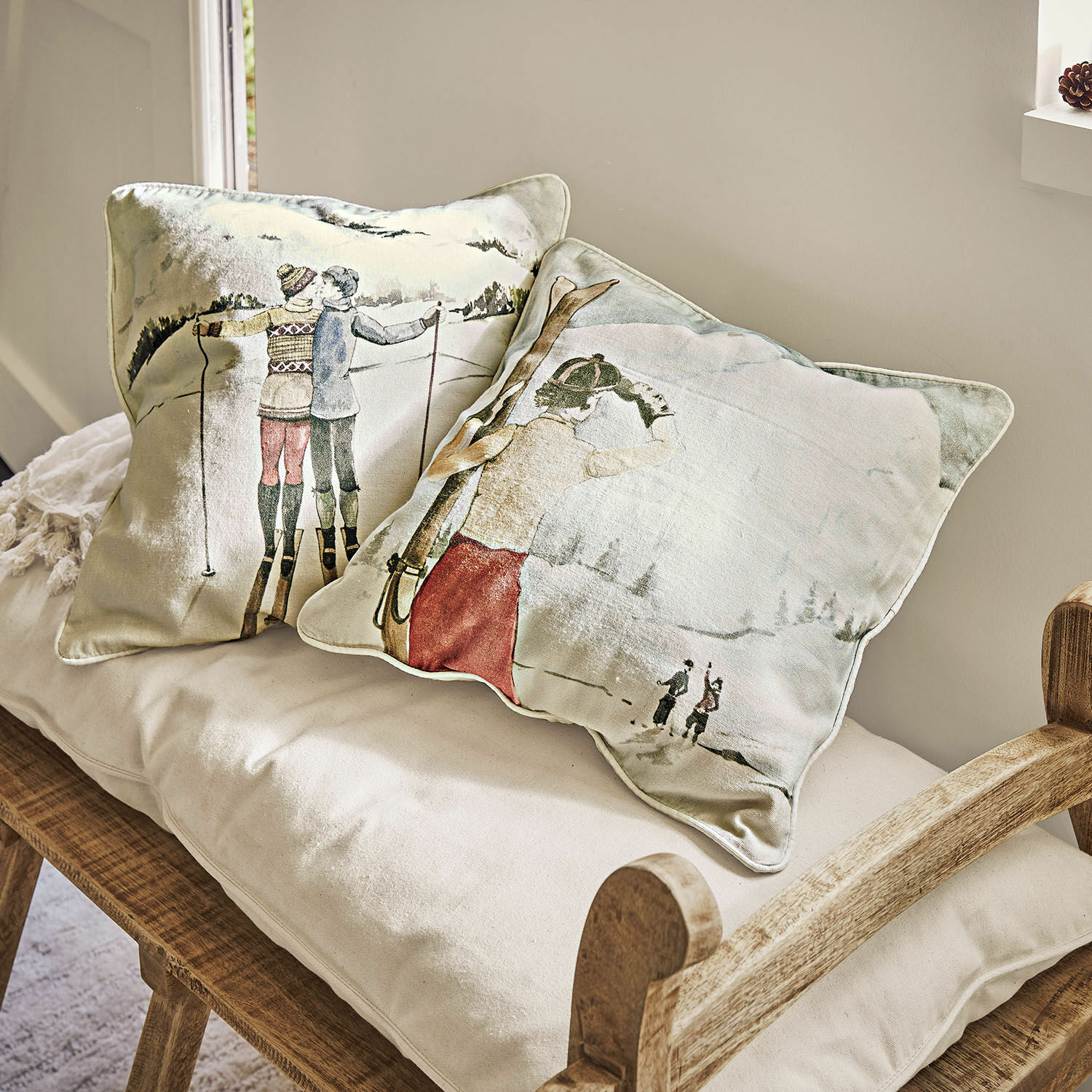 Kussenhoes set van 2 Towyn Decoratieve kussens met winterski-motief op lichte stof op een houten bank