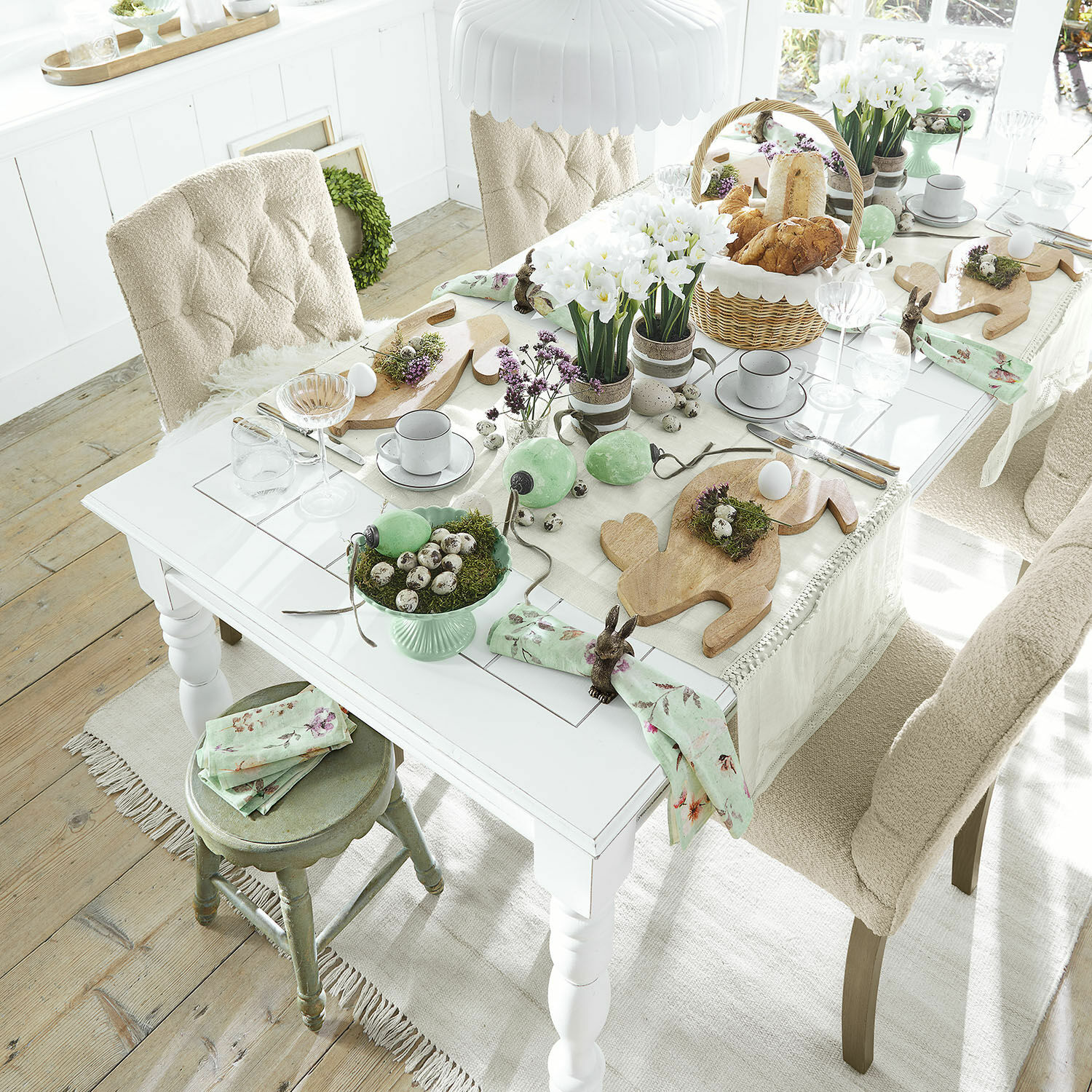 Tafel Thurleigh Lichte tafel met paasdecoratie, houten snijplanken en groene accenten in een gezellige ruimte