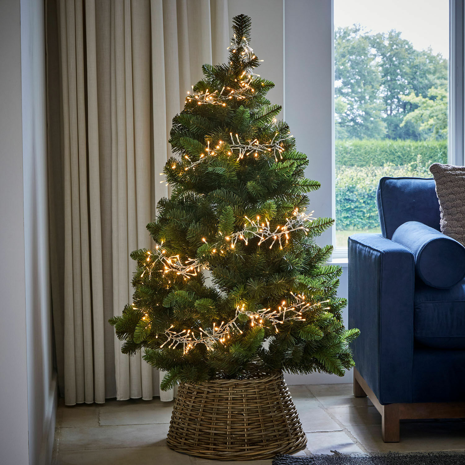 Kunstkerstboom in rieten mand met warme LED-lichtjes voor feestelijke decoratie