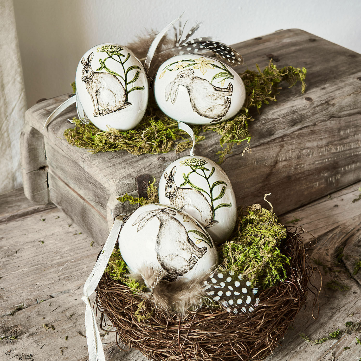 Paasei set van 4 Finna Witte keramische decoratieve eieren met konijn- en plantenmotieven, versierd met veren en mos