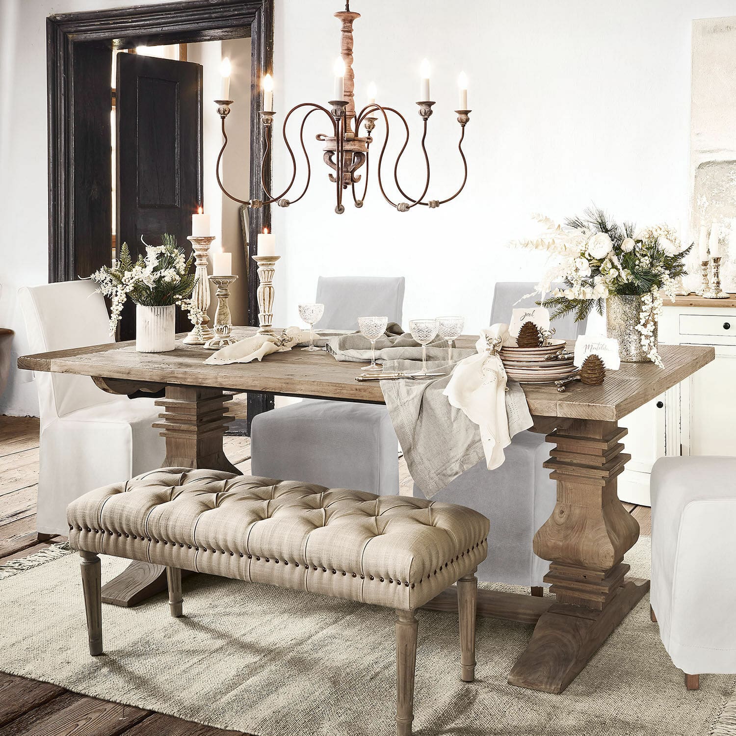 Eettafel Cain Rustieke houten eettafel met beige gestoffeerde bank en decoraties op tafel