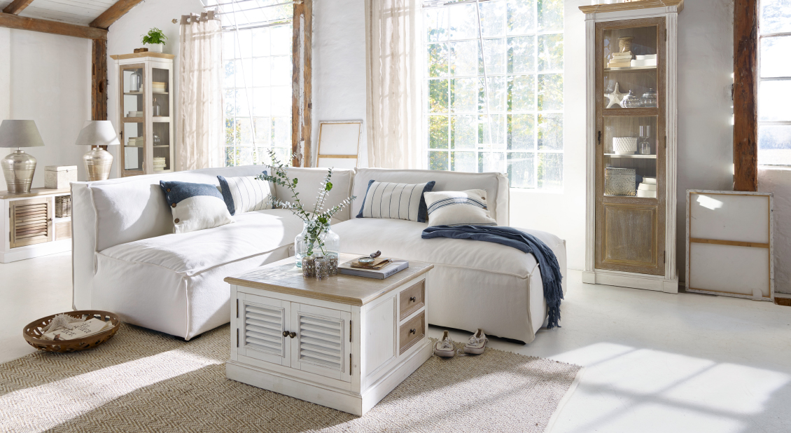 Gezellige witte hoekbank in lichte woonkamer met houten salontafel en Scandinavische decoratie