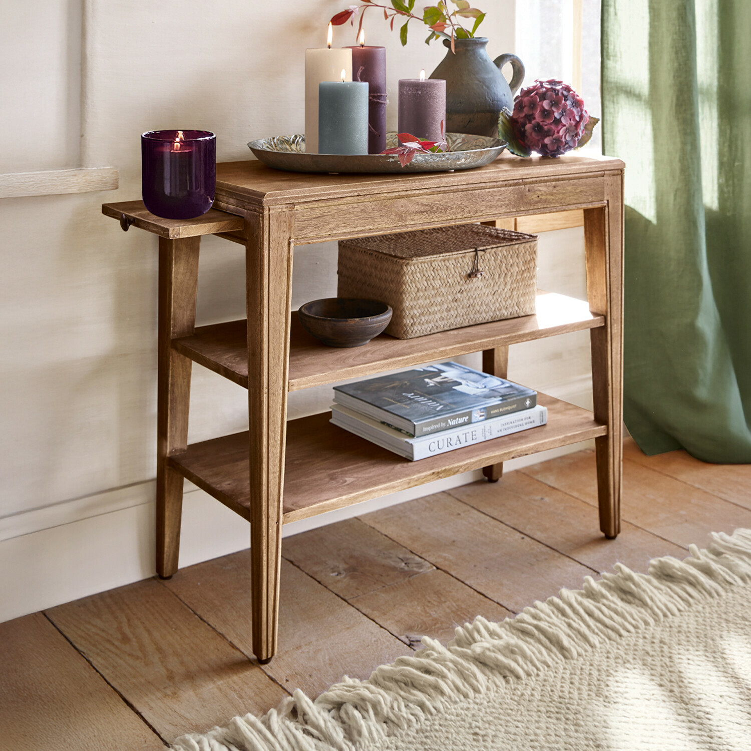 Houten tafel met planken, decoratieve kaarsen en vaas in natuurlijke inrichting
