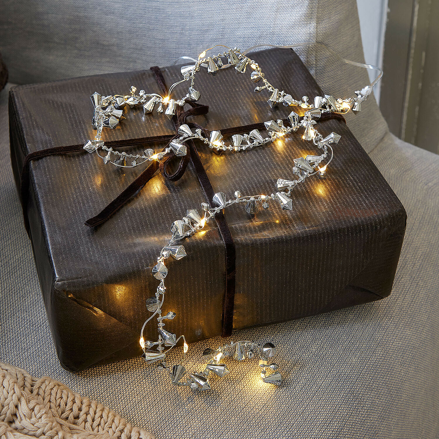Lichtsnoer Bryesa Fijne lichtsnoer met zilverkleurige metalen versieringen op een donker cadeauverpakking