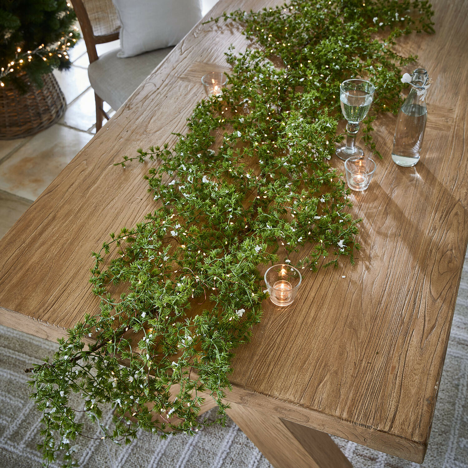 Ledguirlande Kalitha Houten tafel met groene takken en kaarsen, natuurlijke feestelijke tafeldecoratie