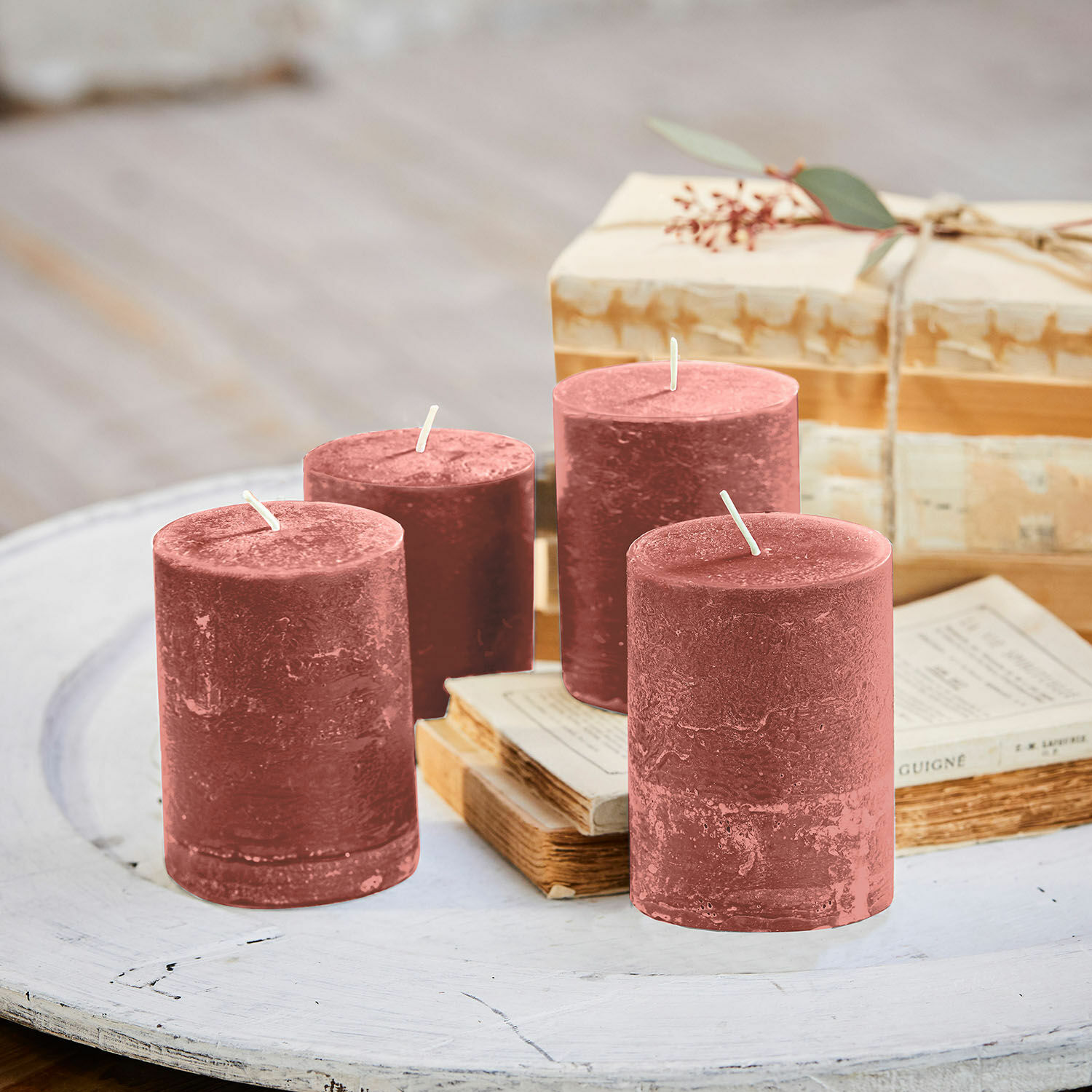 Kaars set van 4 Virrans Set van vier bordeauxkleurige waskaarsen op een witte houten tafel met oude boeken