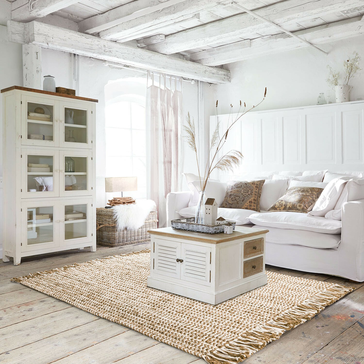 Lichte woonkamer met witte bank, lichte houten kast en natuurlijke jute vloerkleed in Scandinavische stijl