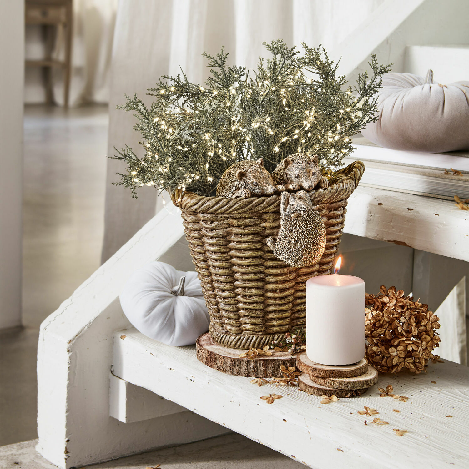 Decoratieve bruine harsmand met drie egels, groene takken en LED-lichtsnoer