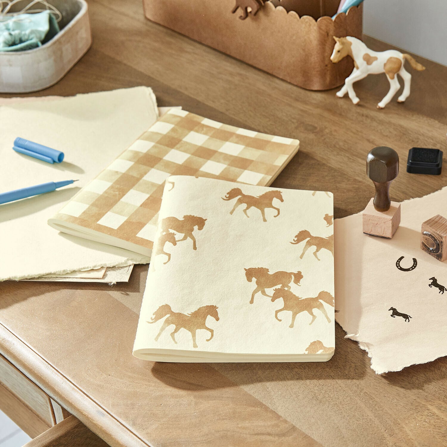 Notitieboekje set van 2 Windermay Notitieboekjes van crèmekleurig papier met paarden- en ruitpatroon op houten bureau met stempels