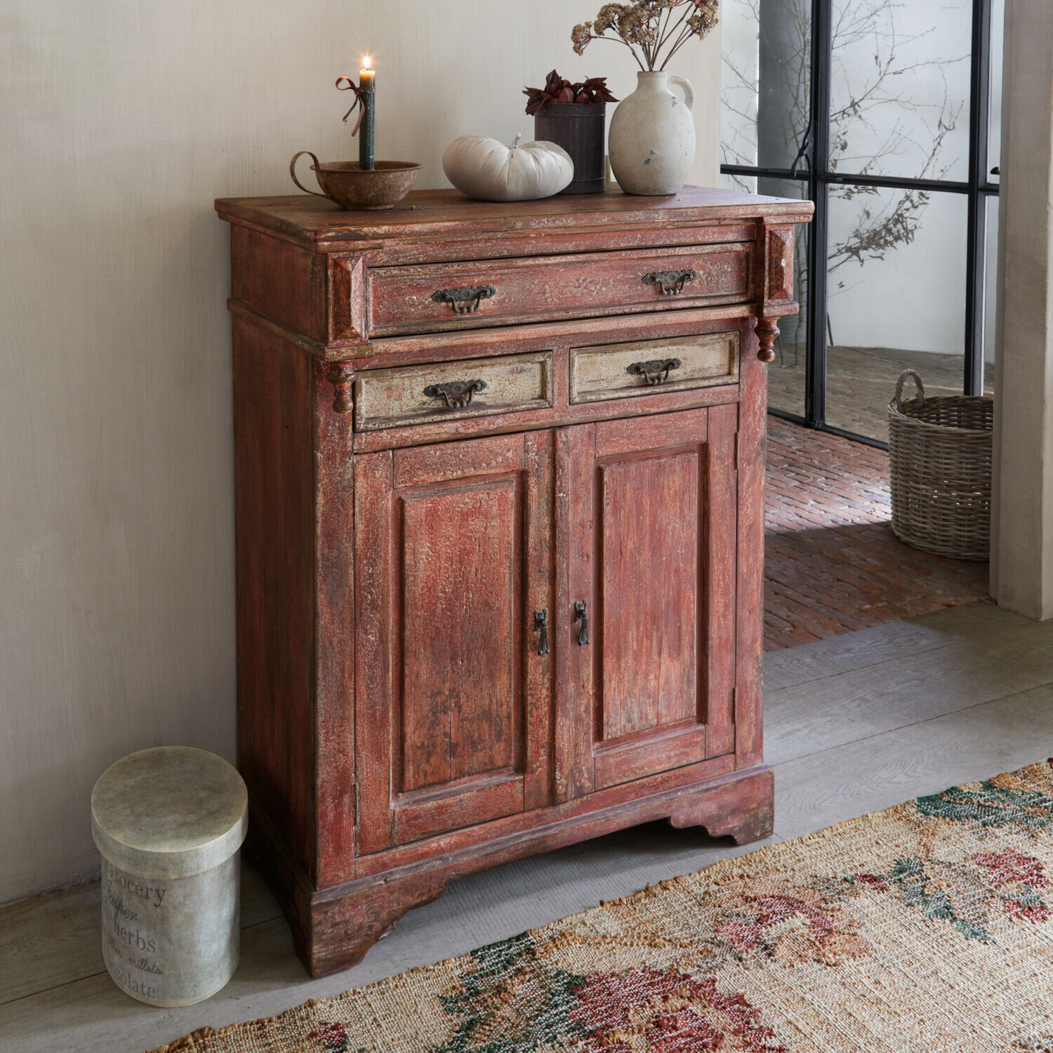 Kastje Jolivarne Rustieke rode houten kast met decoratieve handgrepen en decoraties bovenop