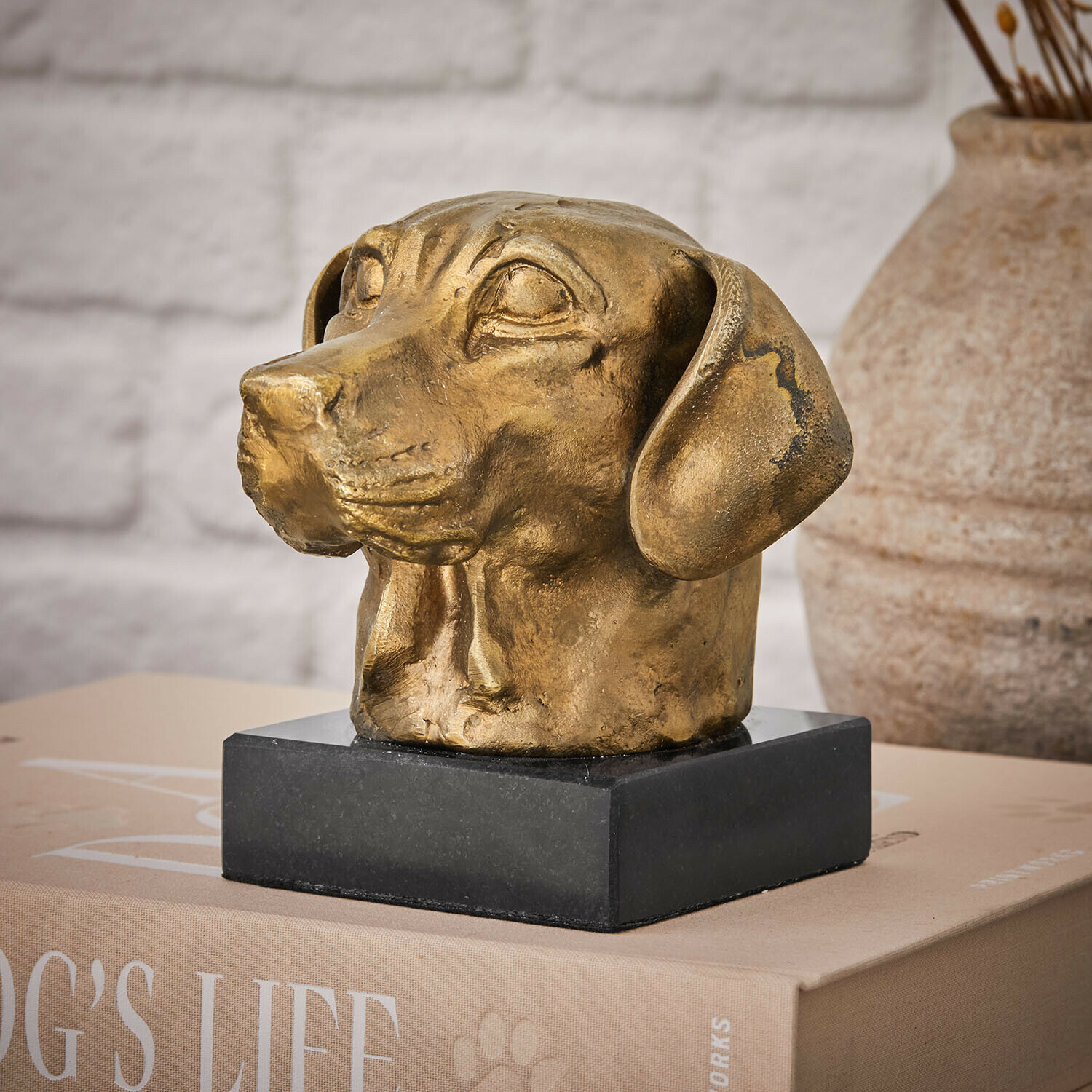Gouden hondenhoofd beeld van metaal op zwarte voet, stijlvolle woondecoratie
