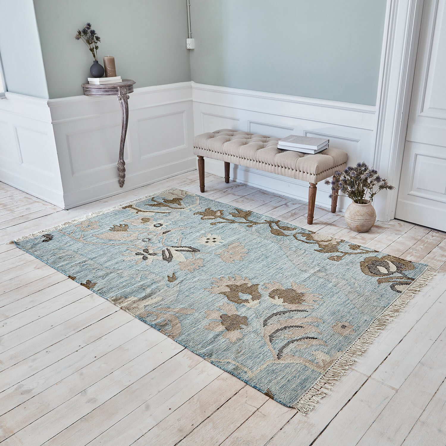 Vloerkleed Nére Blauw-beige vloerkleed met bloemmotief op lichte houten vloer in stijlvolle kamer