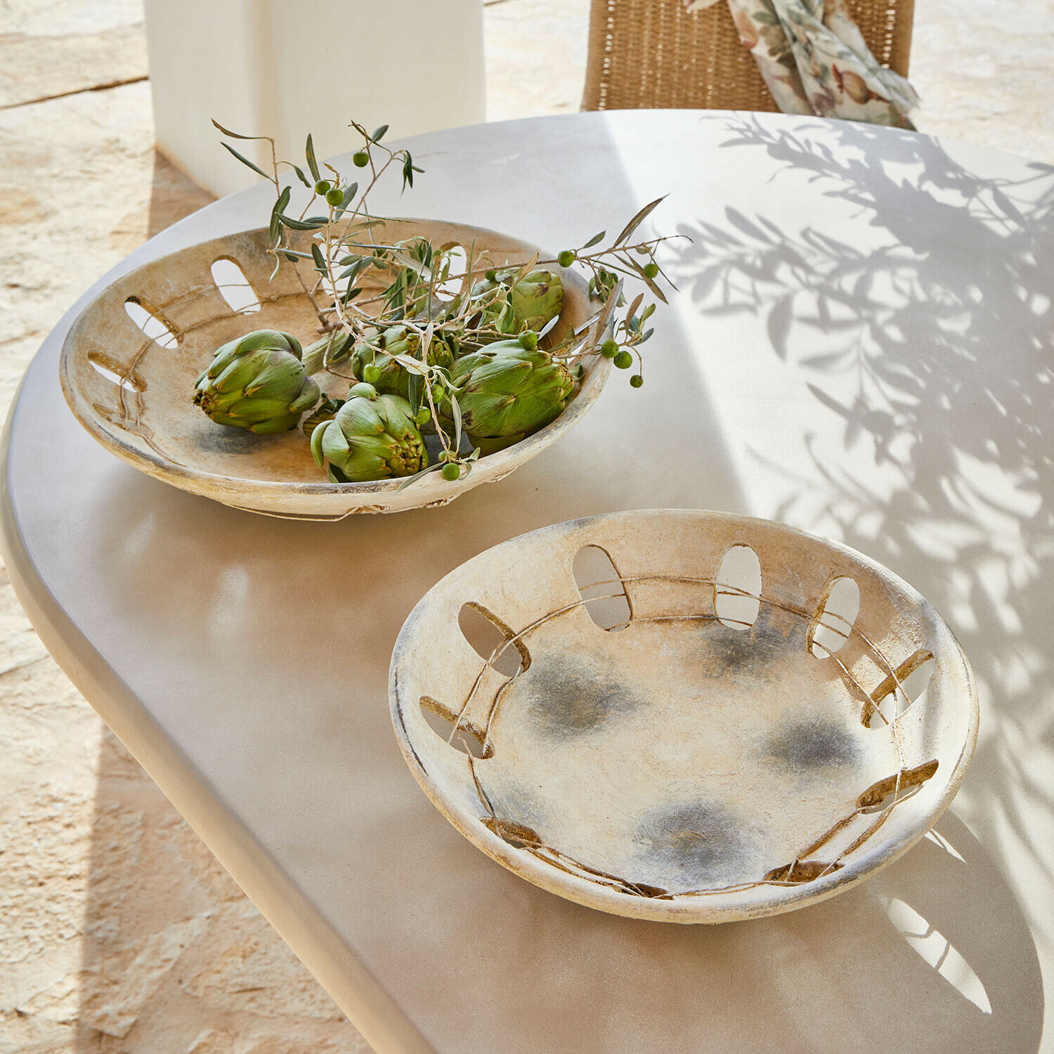 Decoratieve schaal set van 2 Delunas Twee decoratieve beige keramische kommen op tafel, één met groene artisjokken