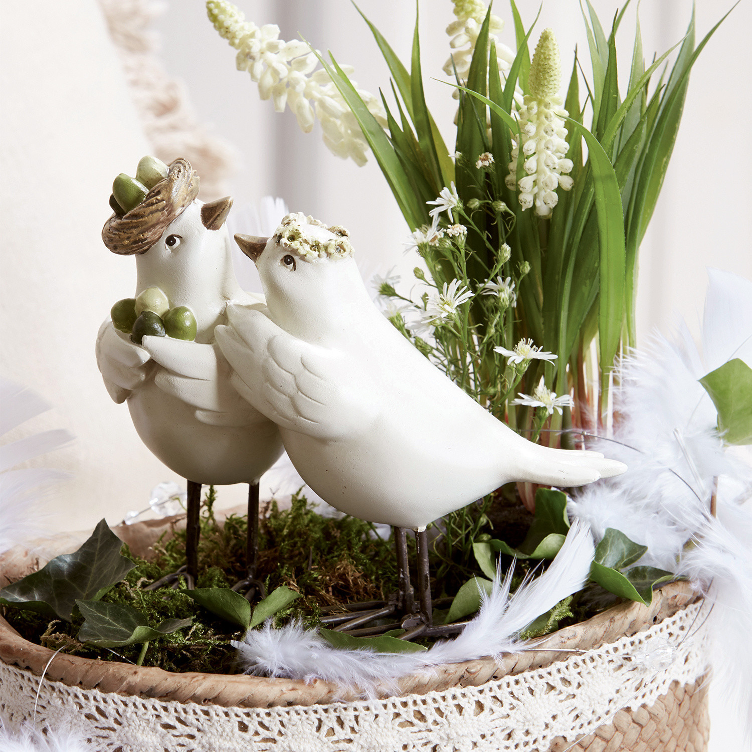 Vogelpaar Orne Witte decoratieve keramische vogels op metalen poten in een rieten mand met groen en bloemen