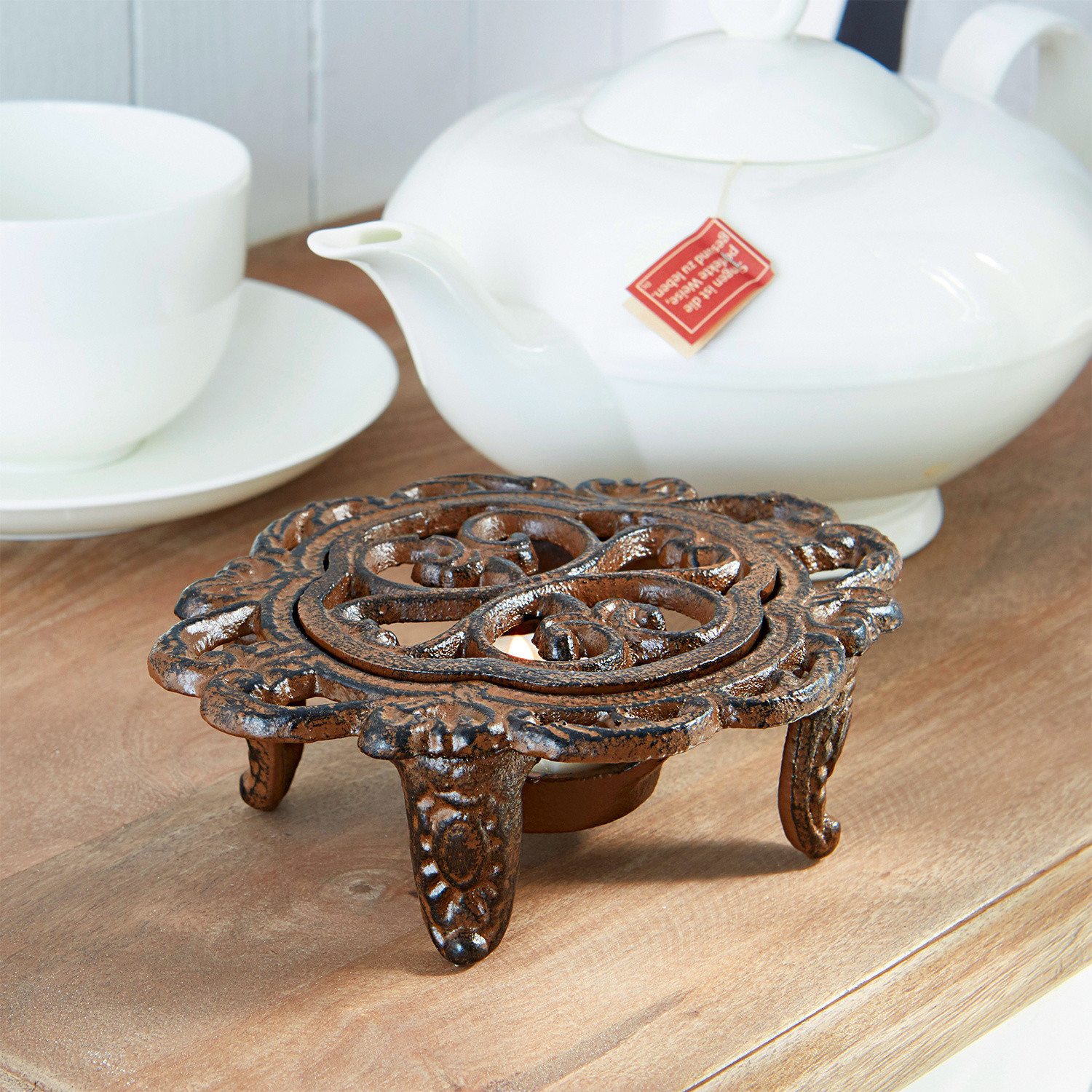 Theepotverwarmer Florian Decoratieve bruine gietijzeren theewarmhouder op houten tafel met wit porselein