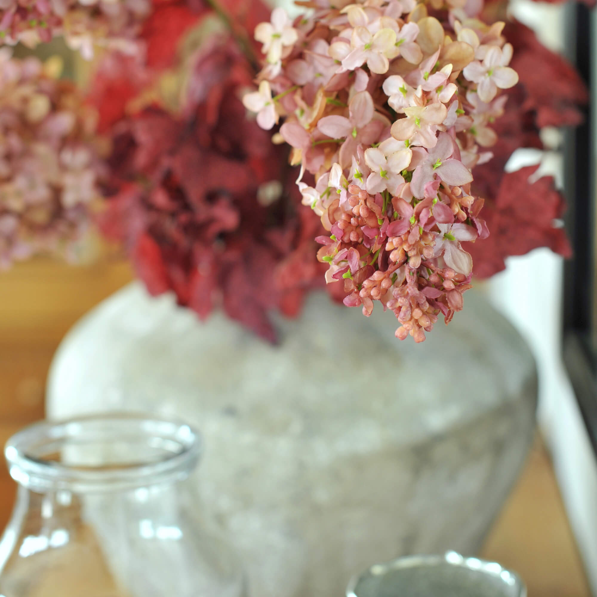 Decoratieve grijze stenen vaas met roze bloemen voor interieurdecoratie