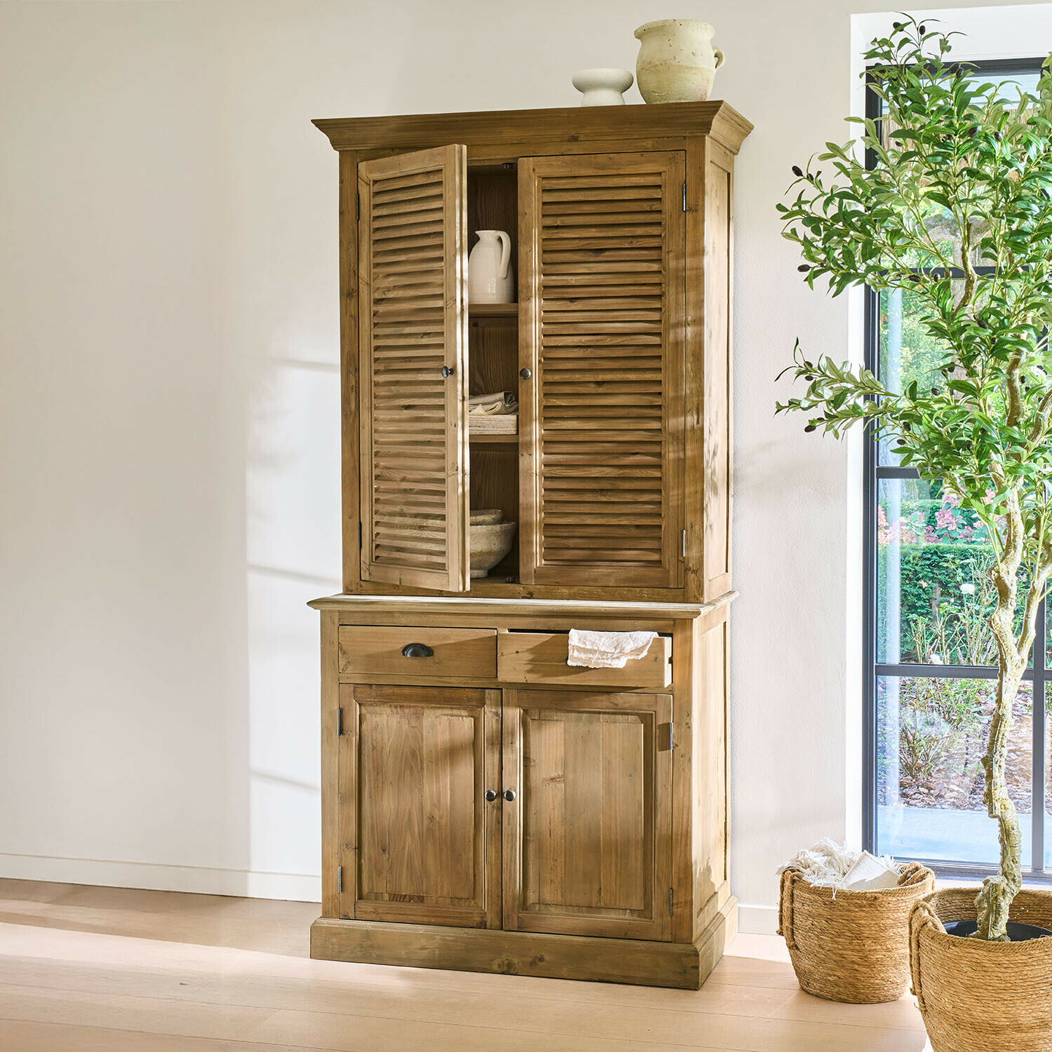 Houten kast met lamellen deuren en lades in natuurlijke kleur, praktische opbergruimte in woonkamer