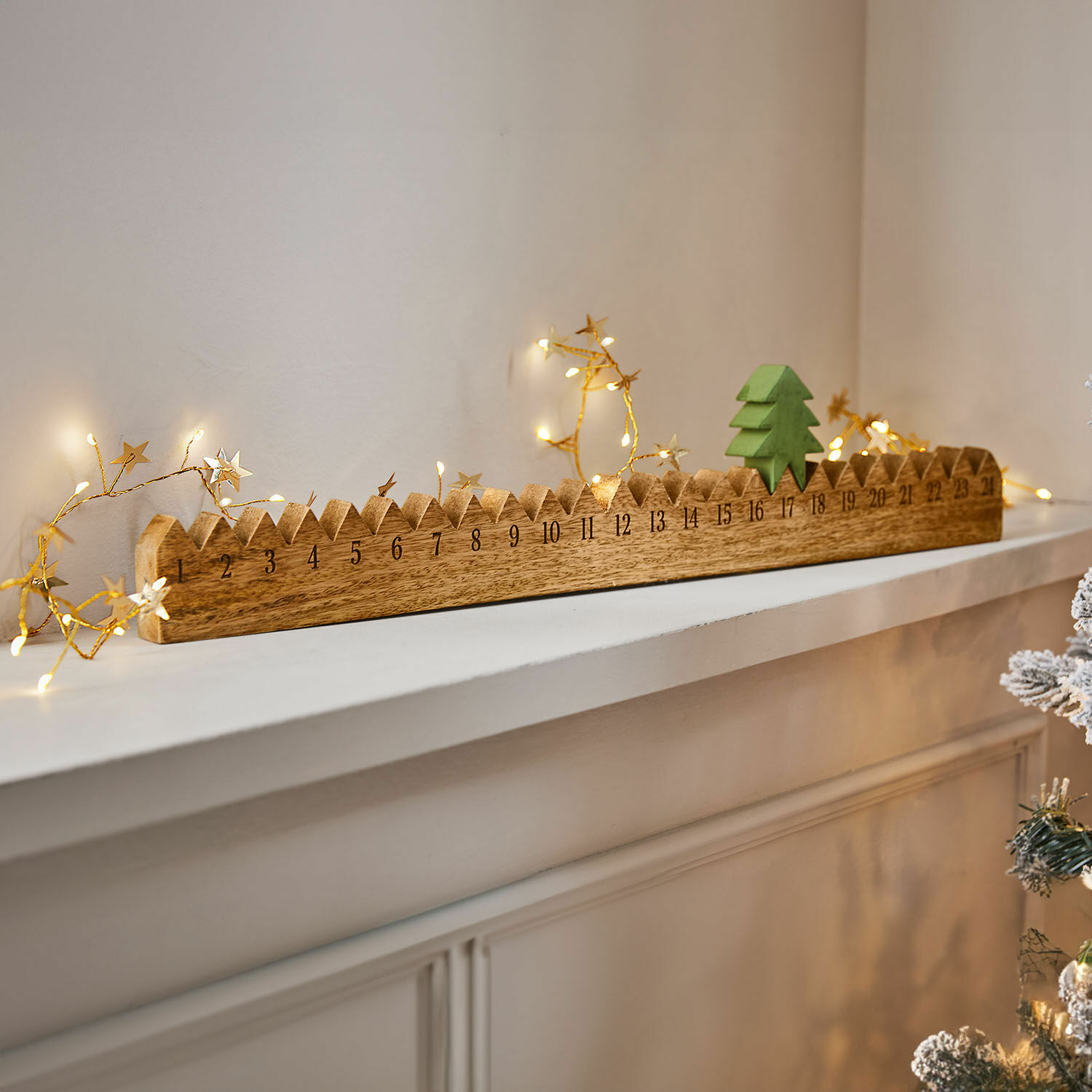 Houten adventskalender met groene kerstboom en LED-lichtjes op witte plank, kerstdecoratie