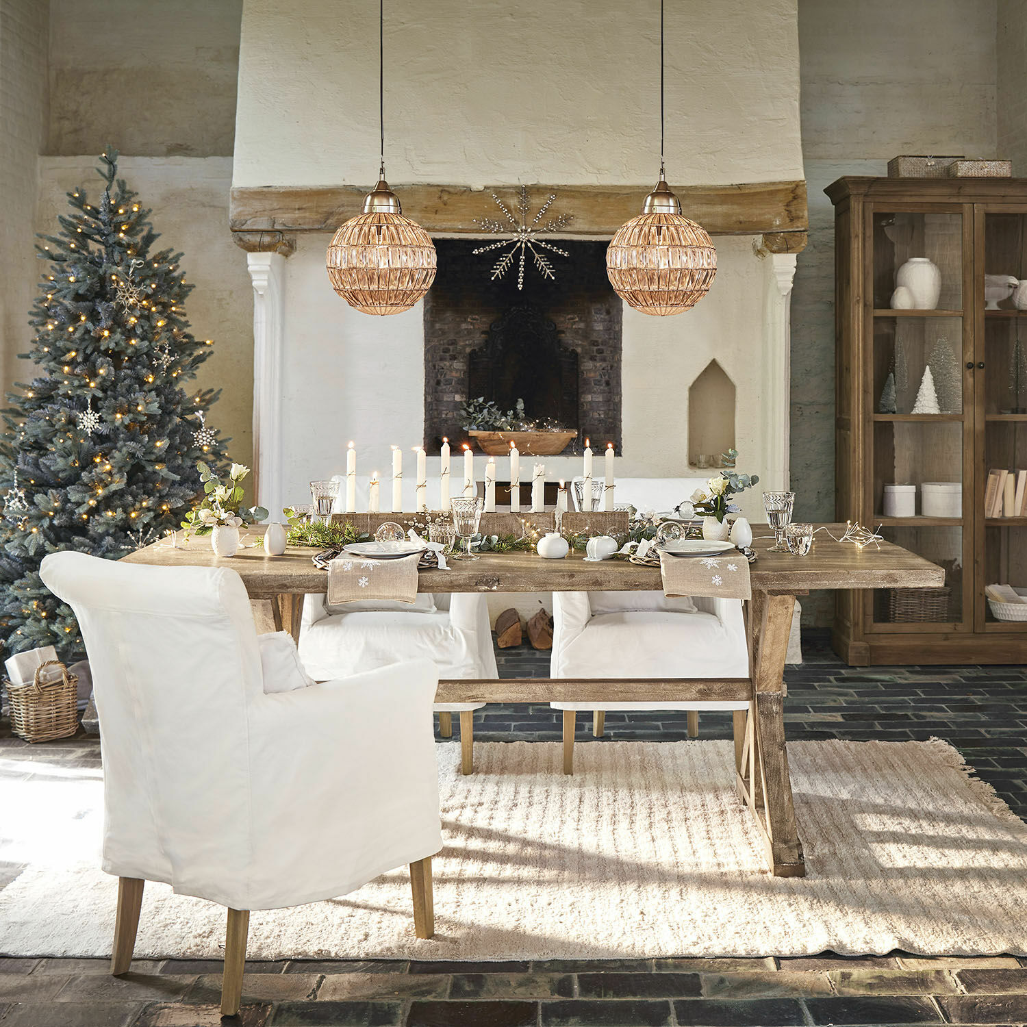 Eettafel Dolignon Rustieke houten tafel met witte stoelen en kerstdecoratie in een gezellige woonkamer met open haard