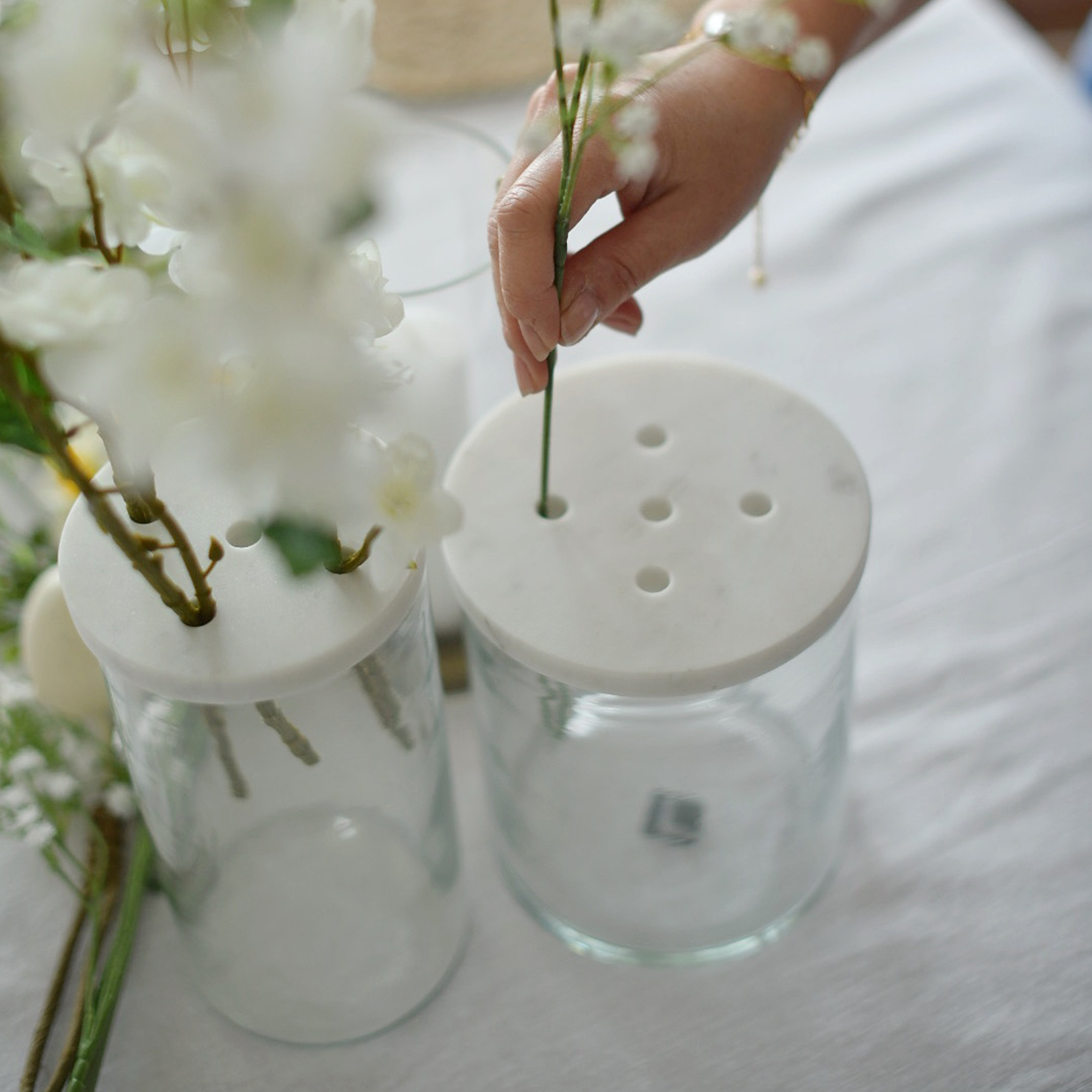 Glazen vaas met wit marmeren deksel met gaten voor bloemschikken op tafel