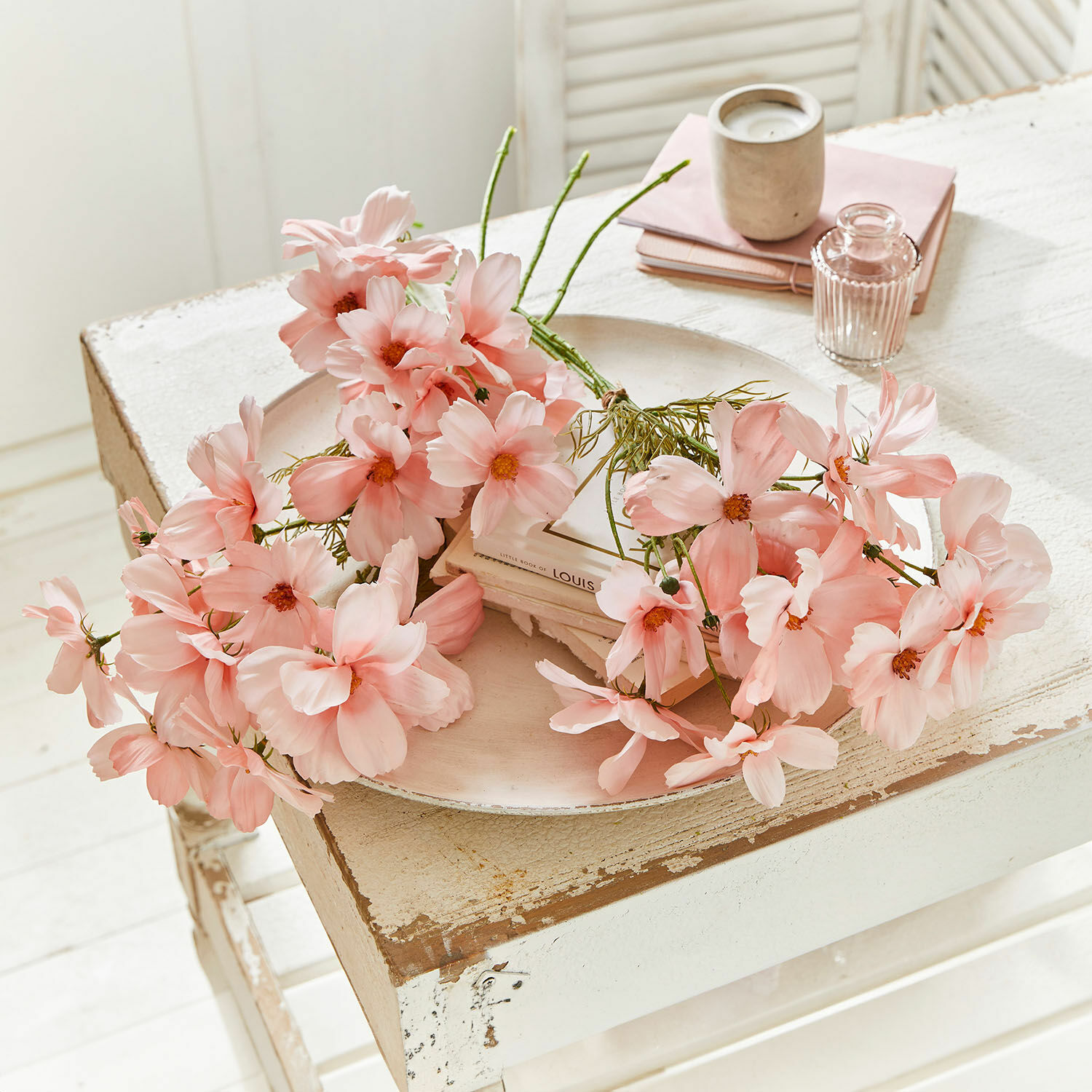 Sierboeket Tilla Delicate roze decoratieve bloemen op een witte, verweerde houten tafel voor interieurdecoratie.
