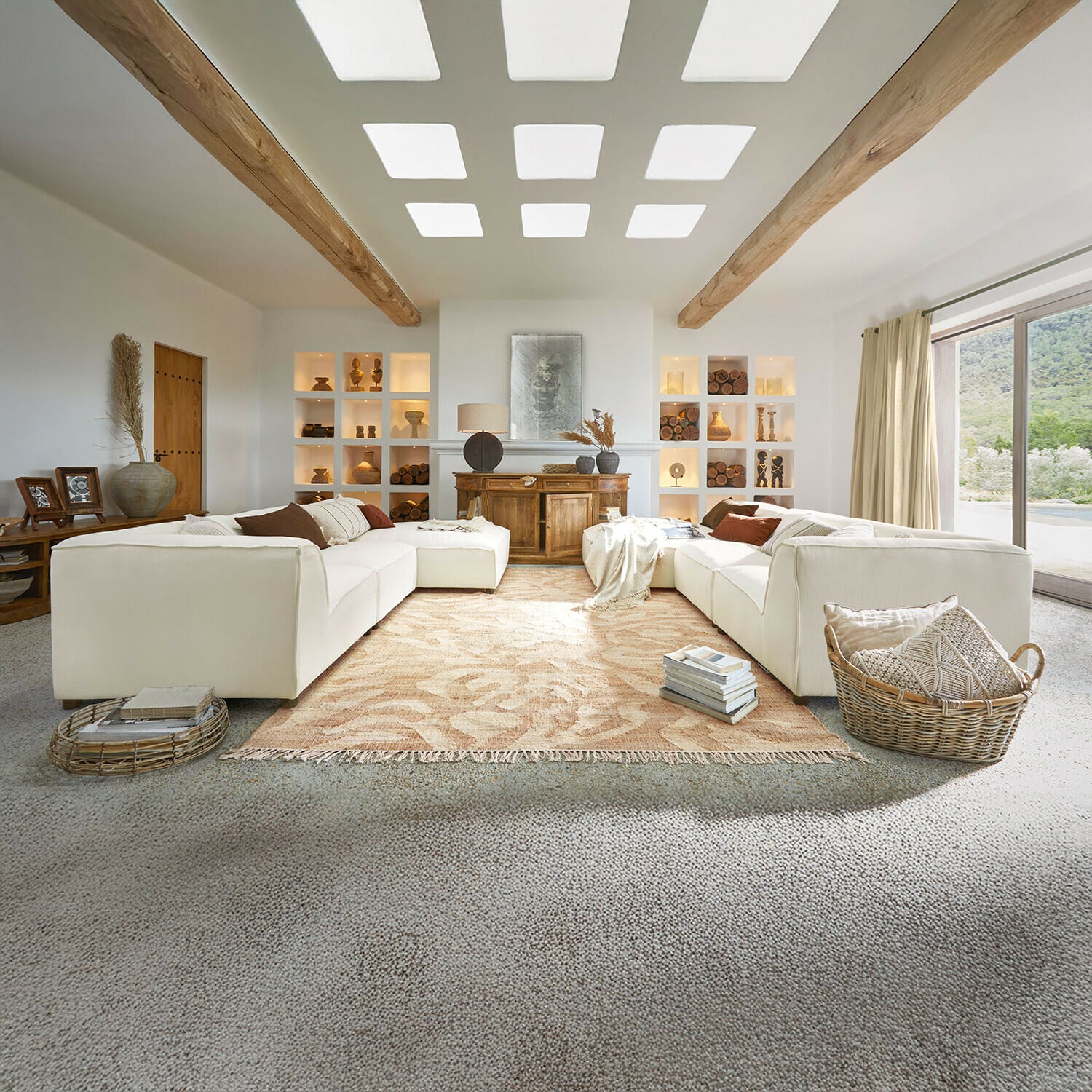Bank McLean Ruime woonkamer met witte bank, houten balken, natuurlijke decoraties, beige vloerkleed en groot raam