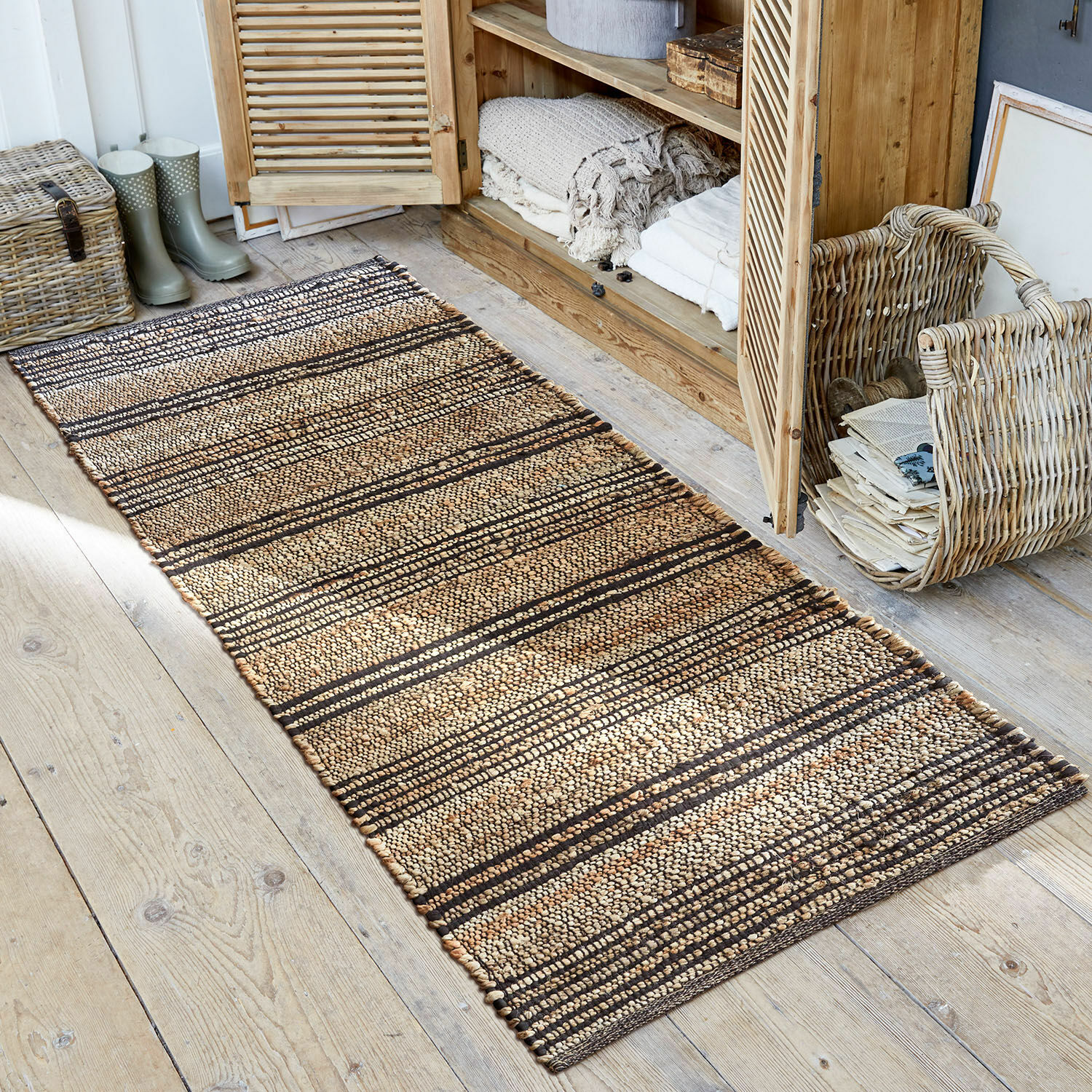 Natuurlijke jute vloerkleed met bruin-beige strepen op lichte houten vloer, interieurdecoratie